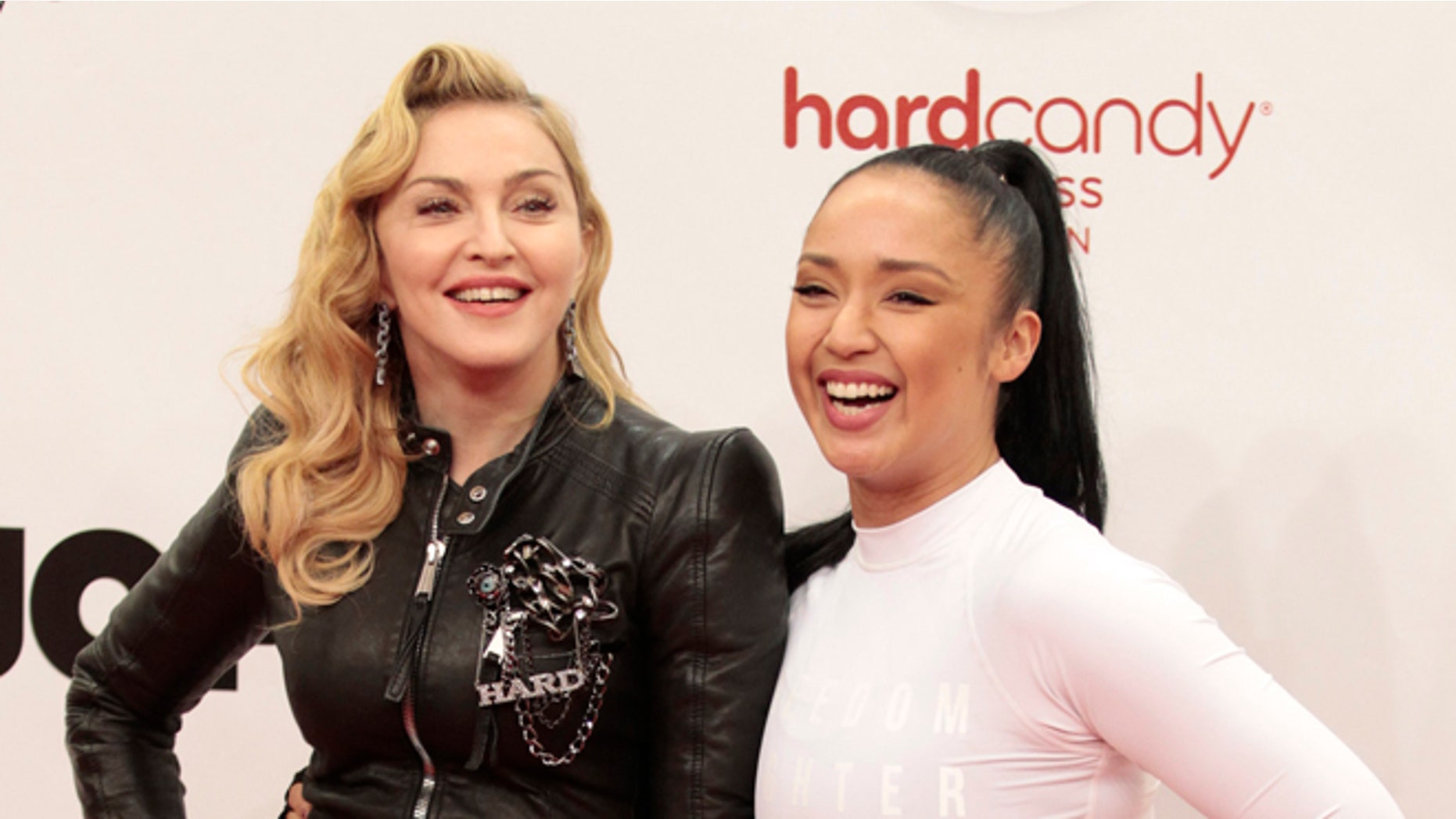 October 17, 2013. U.S. singer Madonna (L) poses with her personal fitness trainer Nicole Winhoffer to promote her latest gym in her Hard Candy Fitness centre chain in Berlin.
