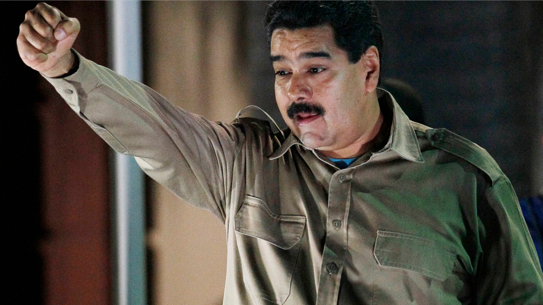 El presidente de Venezuela Nicolás Maduro sostiene los documentos que le otorgan facultades para gobernar por decreto mientras saluda a simpatizantes en el palacio presidencial de Miraflores, en Caracas, Venezuela, el martes 19 de noviembre de 2013. Maduro promulgó dos dÃas después las dos primeras leyes. (AP Foto/Ariana Cubillos)