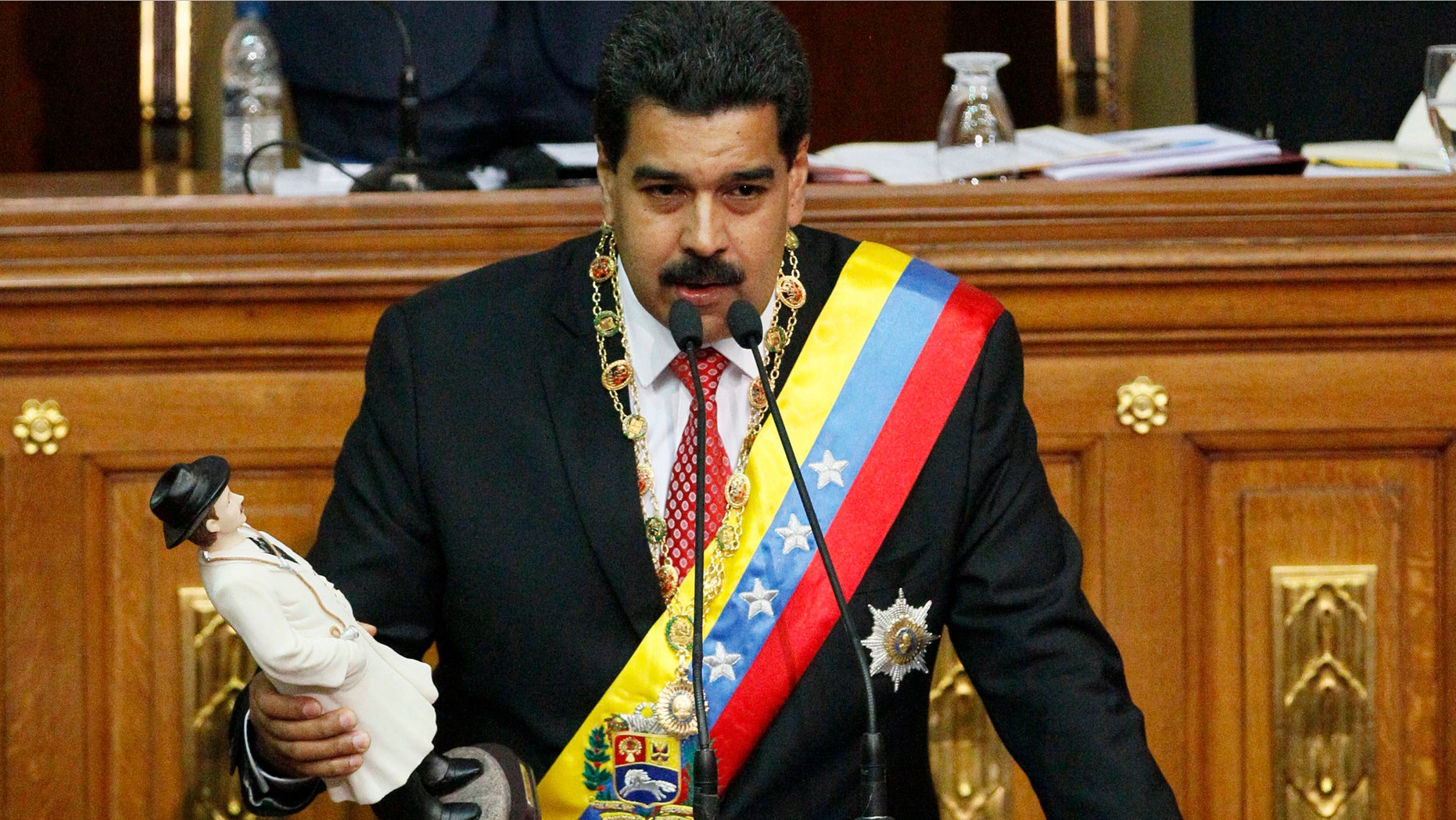 Maduro holds a statue of the beloved physician folk-saint Dr. Jose Gregorio Hernandez as he delivers a speech at the National Assembly in Caracas, Venezuela, Tuesday, Oct. 8, 2013.