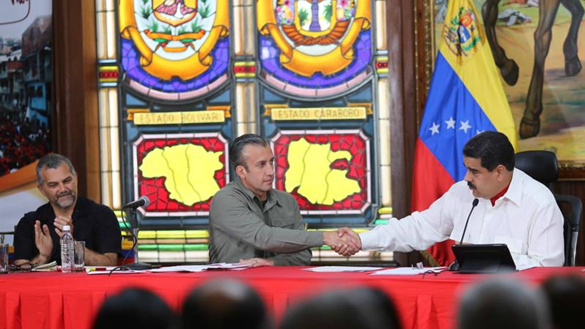 Venezuela's President Nicolas Maduro (R) shakes hands with Vice President Tareck El Aissami during a press conference in Caracas, Feb. 14, 2017.