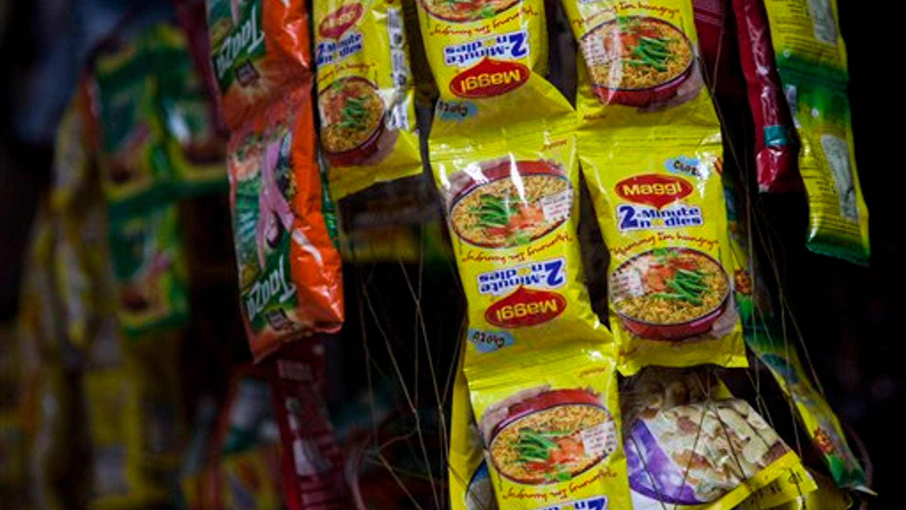 Packets of Maggi noodles hang on display at a shop in New Delhi, India, Wednesday, June 3, 2015. (AP Photo/Tsering Topgyal)