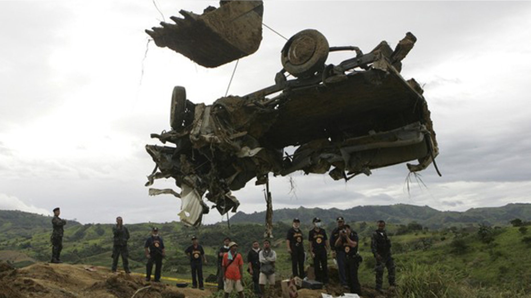A backhoe lifts the wreckage of a local television network's vehicle that was unearthed from a shallow grave at the site of a massacre of a political clan that included several journalists in the outskirts of Ampatuan, Maguindanao in southern Philippines in this November 25, 2009 file photo. The 2009 massacre of 57 people, including 31 journalists, in the southern province of Maguindanao was horrific even by the standards of the Philippines, whose restive south is riven by political and insurgent violence.