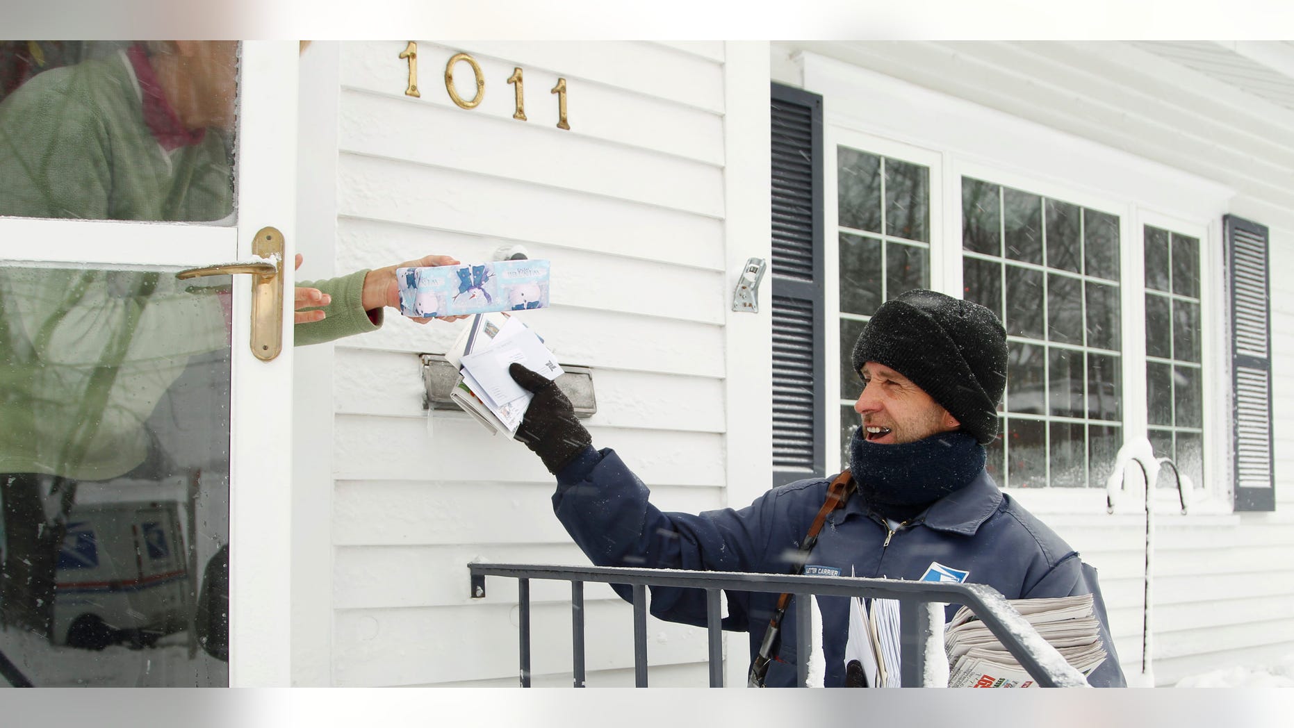 FILE: Dec. 20, 2012: Mail carrier Mike Perkins delivers mail in the snow along Fletcher Avenue in Waterloo, Iowa.