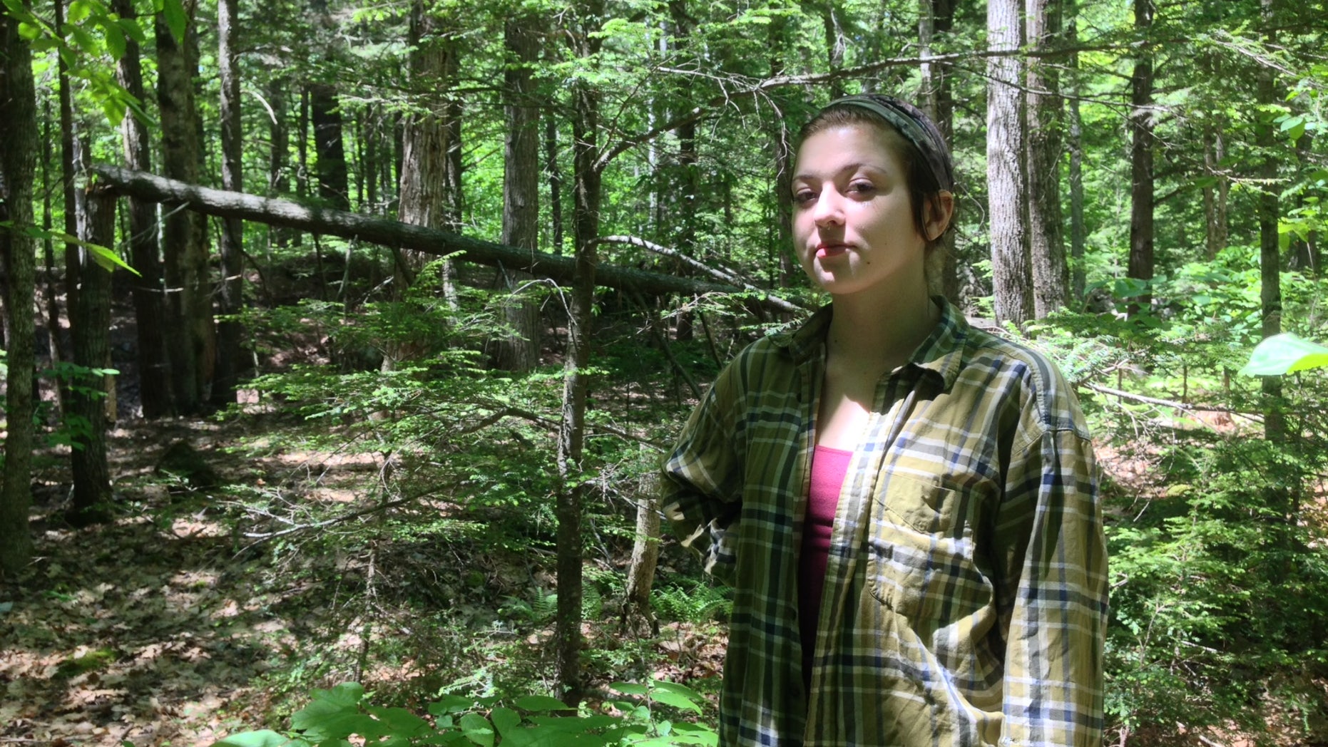 Rachel Borch, 21, stands in the woods near her home in Hope. Borch was attacked while on a jog in woods near her home by a rabid raccoon and had to drown the animal in self defense. (Alex Acquisto, Bangor Daily News)