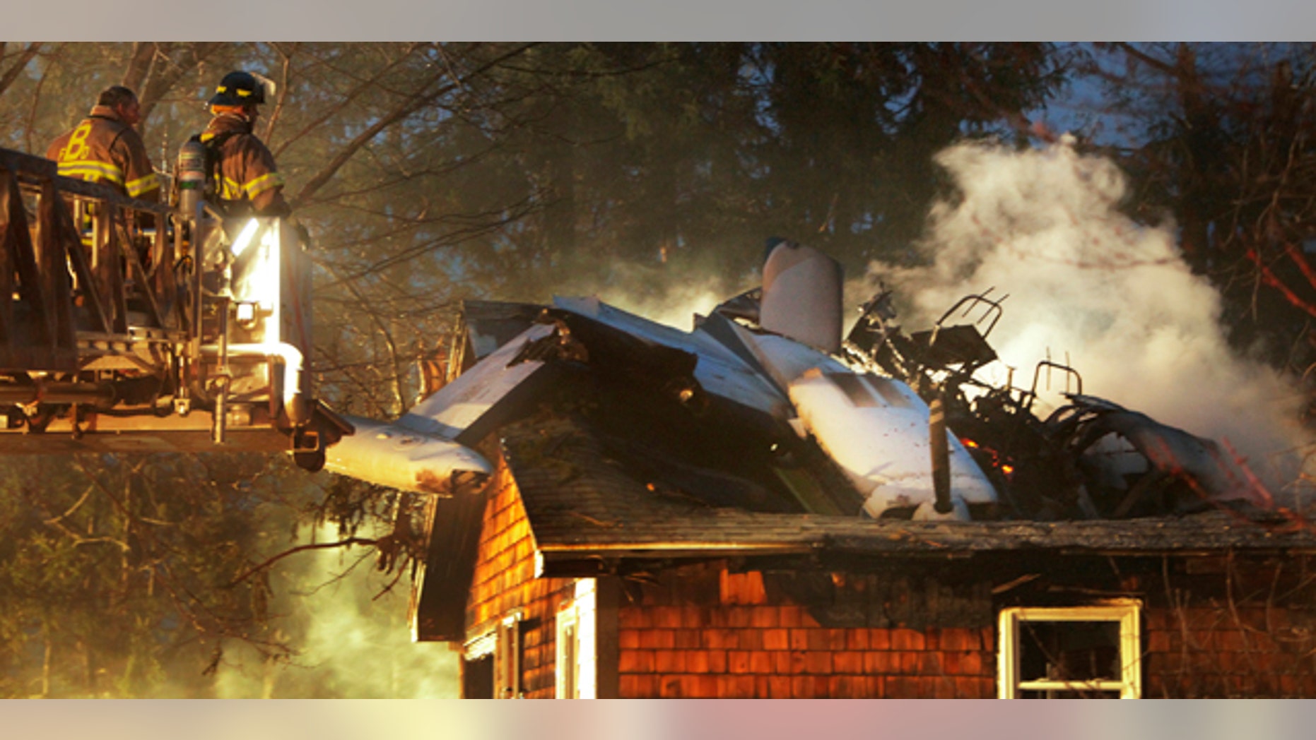 April 10: Firemen work at the scene where a small plane crashed into a house near the Biddeford, Maine