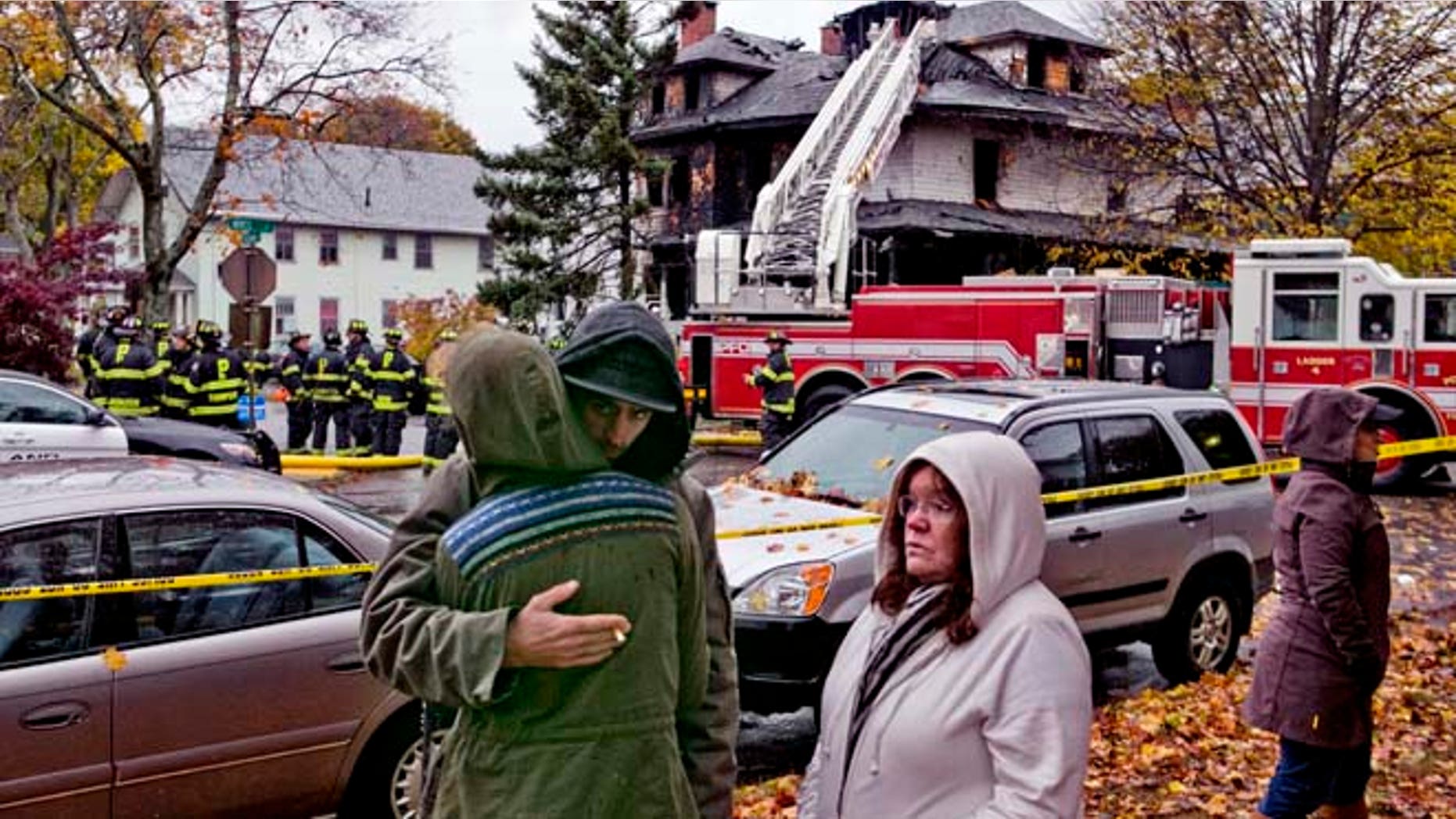 Nov. 1, 2014: Friends of a victim of a fatal apartment building fire console each other in Portland, Maine. (AP)