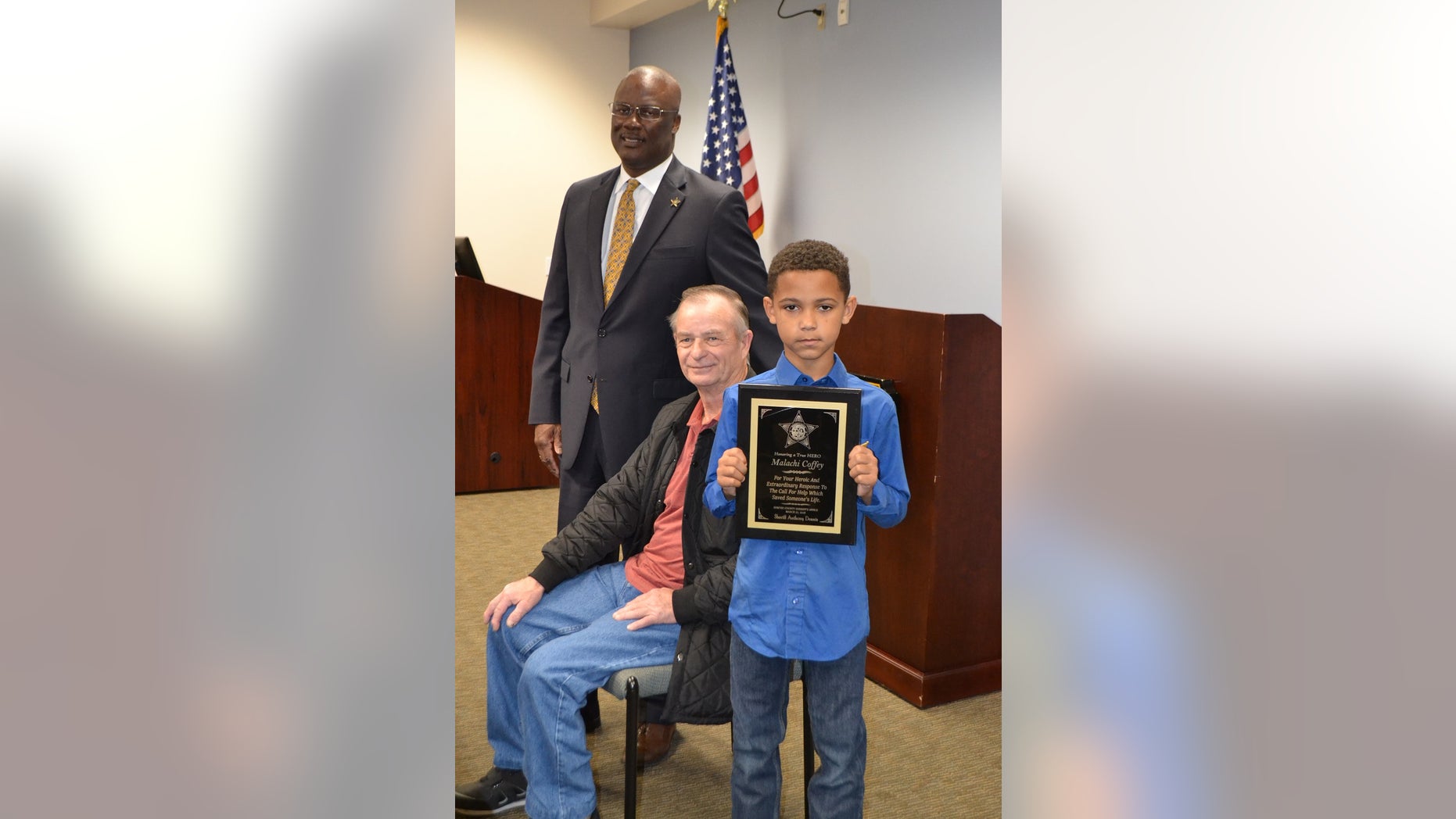 Malachi Coffey (right) stands next to Allen Clemmons (center) and Sumter County Sheriff Anthony Dennis (left). The sheriff's office presented Malachi with a plaque for his heroic deed.