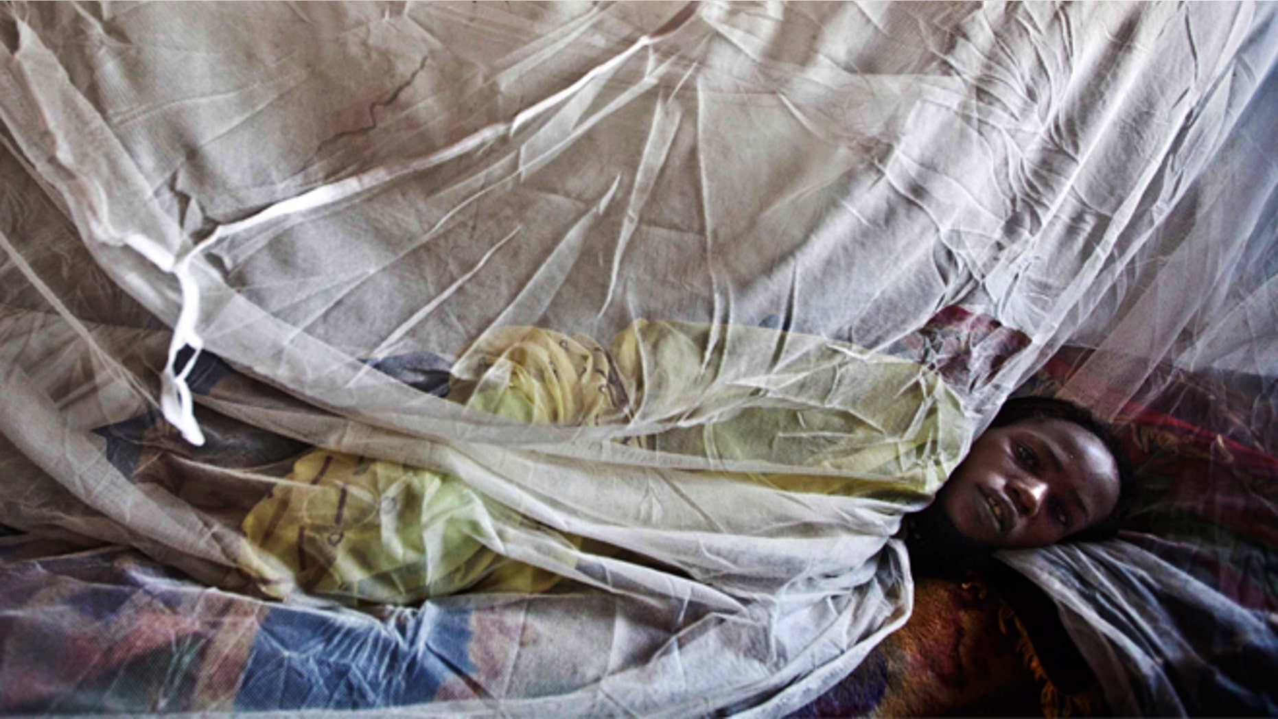 A woman suffering from malaria rests on a bed at a hospital in El Sereif village, North Darfur, Sudan. (AP Photo/UNAMID, Albert Gonzalez Farran, File)