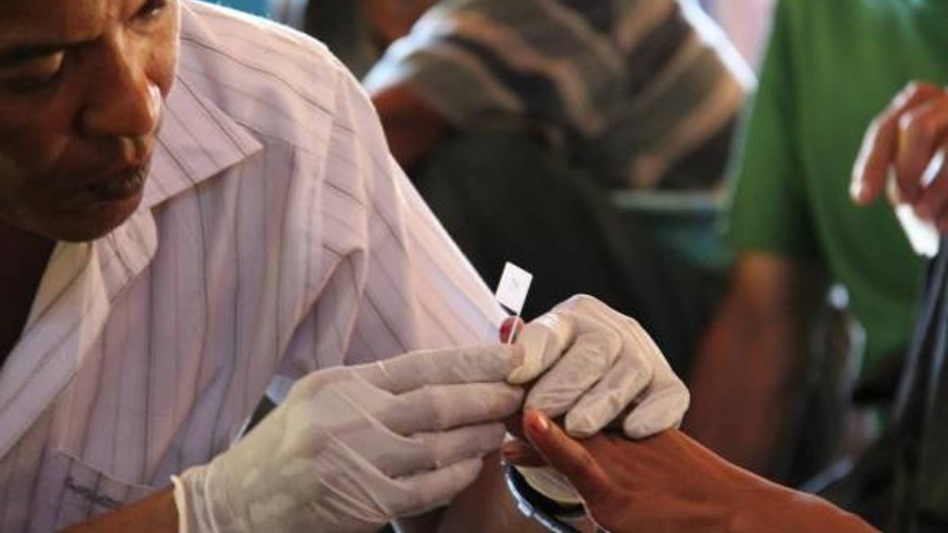 Nov. 28, 2011: A government health worker takes a blood sample to be tested for malaria in Ta Gay Laung village hall in Hpa-An district in Kayin state, south-eastern Myanmar.