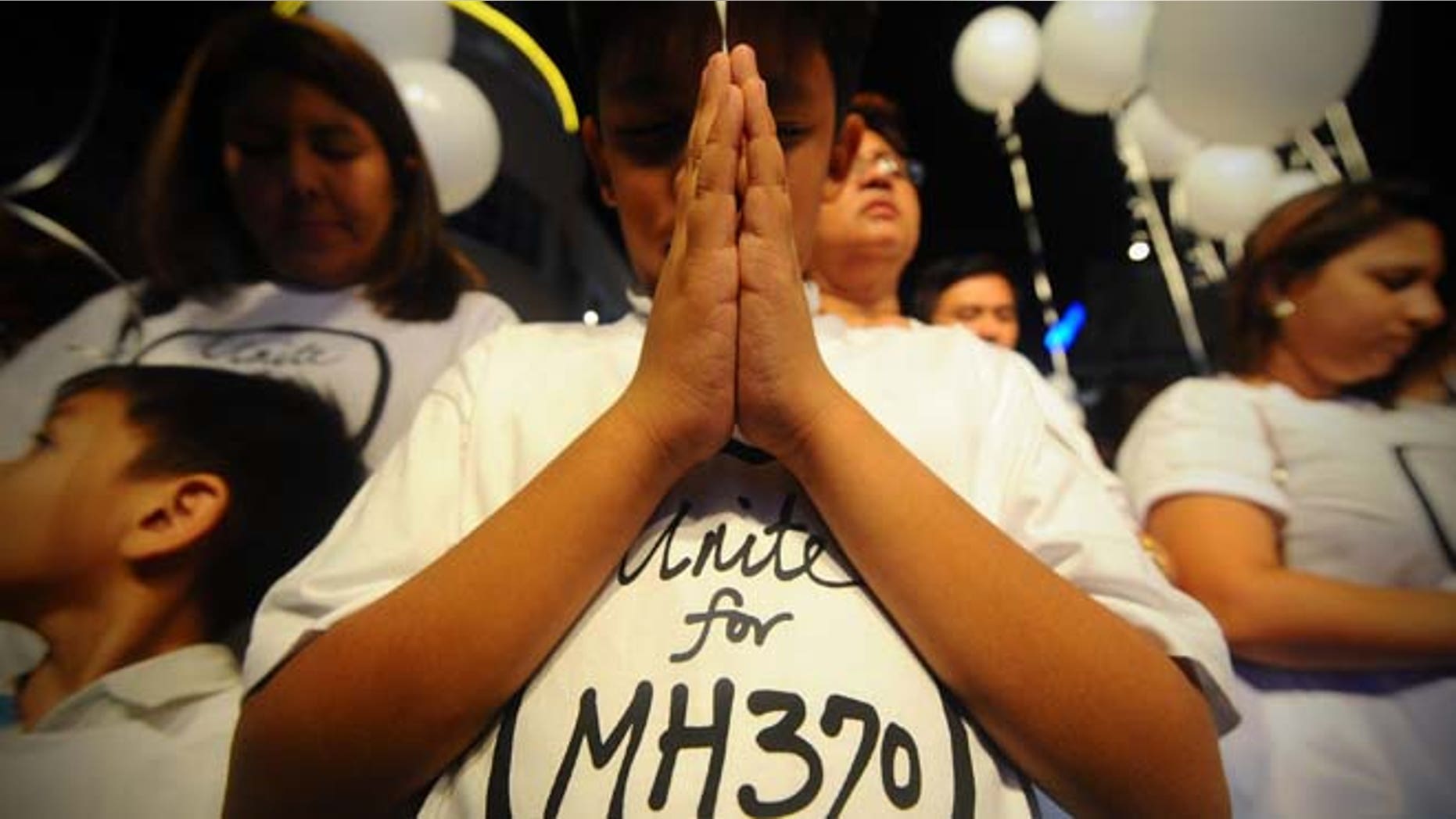 March 18, 2014: A young Malaysian boy prays at an event for the missing Malaysia Airline Flight 370 at a shopping mall in Petaling Jaya on the outskirts of Kuala Lumpur, Malaysia.
