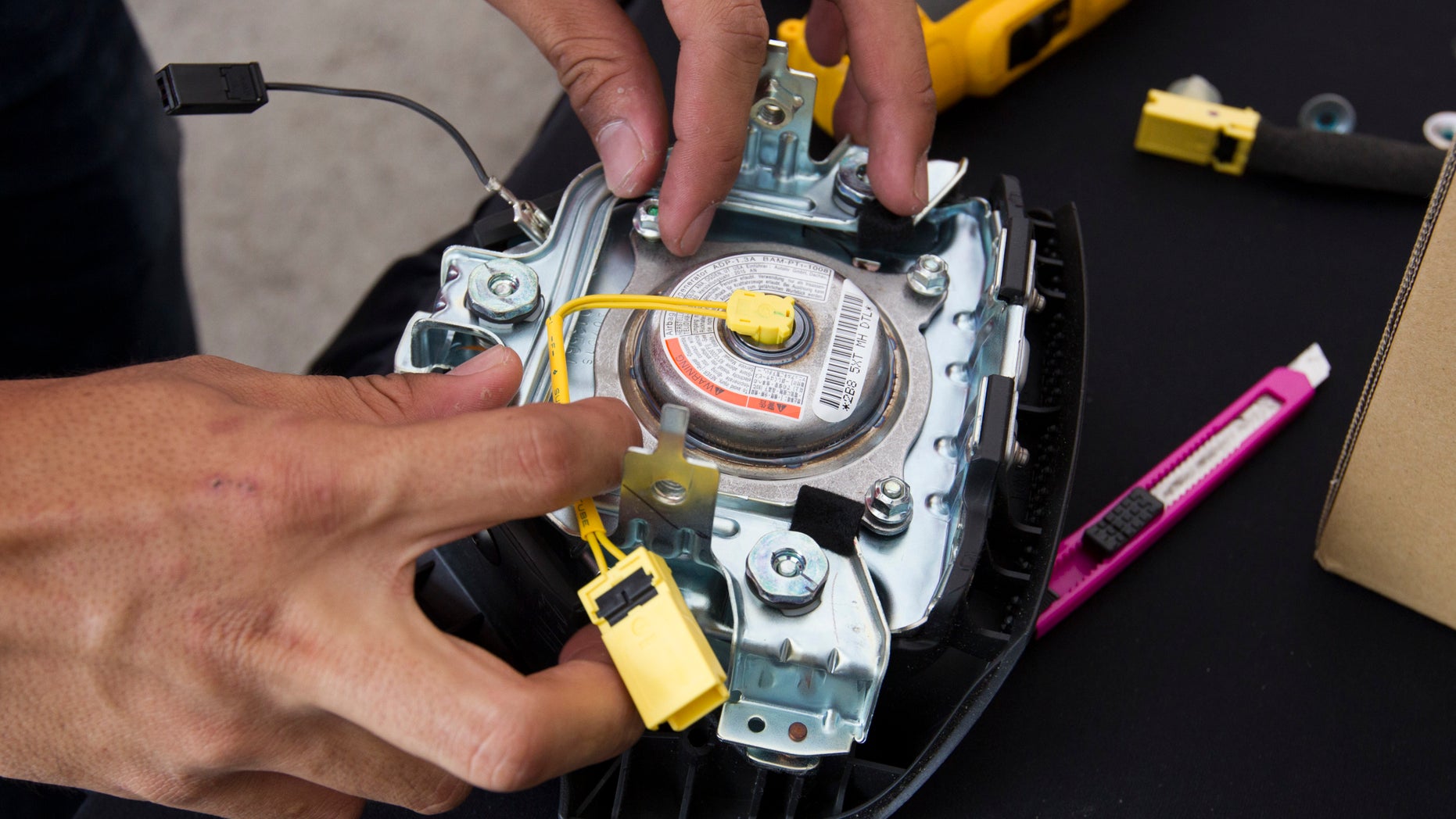 In this Sunday, Nov. 20, 2016, photo, a Honda technician works on an air bag inflator during a free air bag replacement event in Kuala Lumpur, Malaysia. Five Malaysians have died in accidents linked to faulty Takata air bags that are at the center of one of the worldâs largest auto recalls. (AP Photo/Lim Huey Teng)