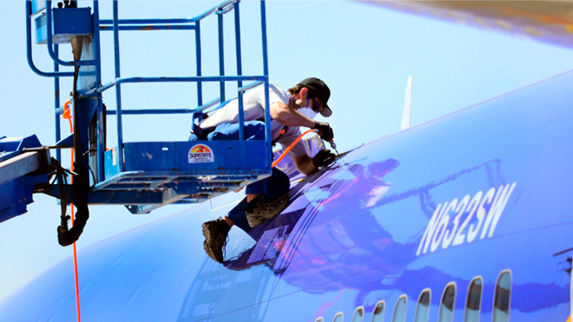 April 3, 2011: This photo shows a member of the National Transportation and Safety Board investigating the emergency landing of Southwest Airlines flight 812 cutting away a portion of the planes fuselage in Yuma, Ariz.