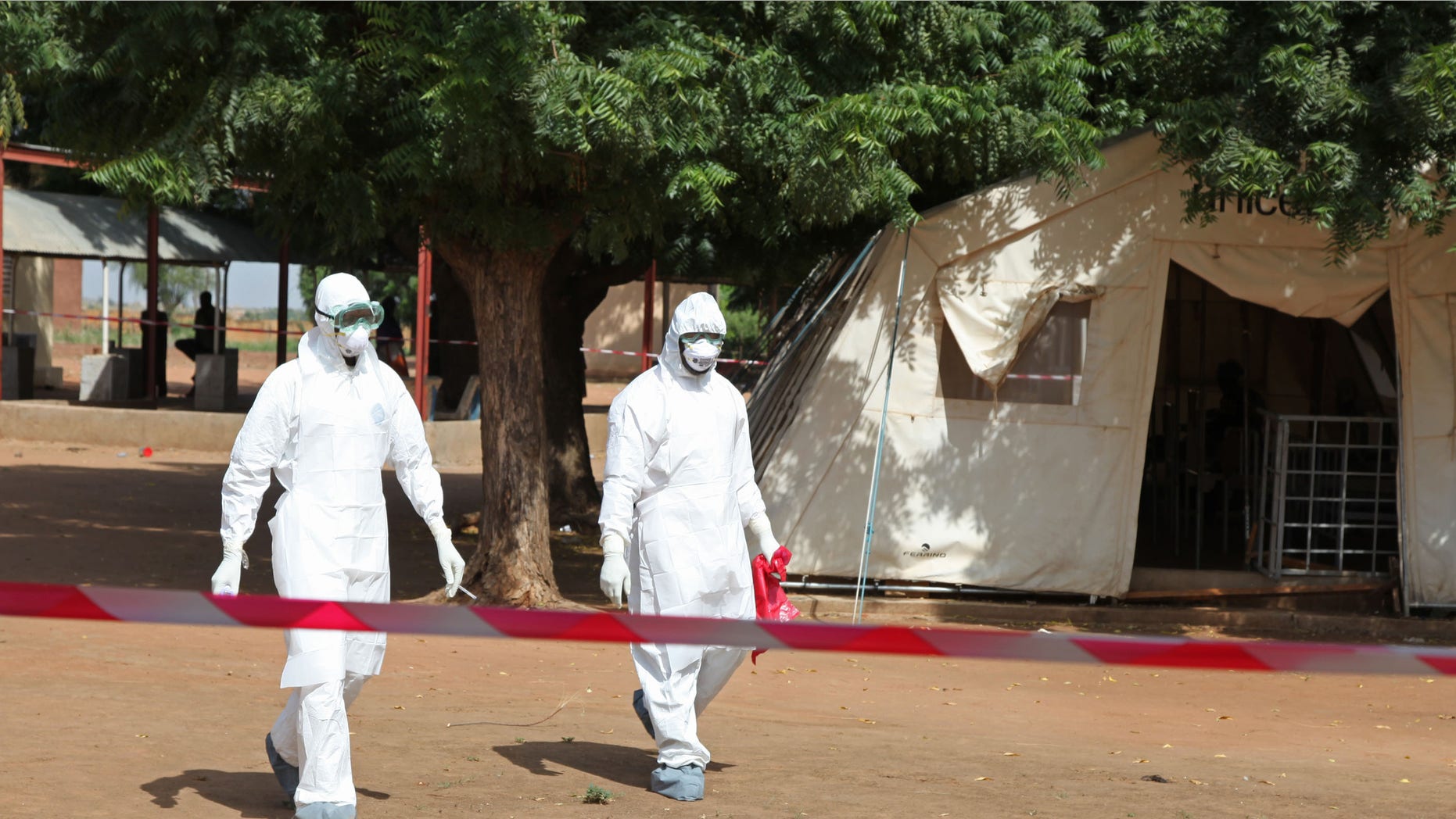 Oct. 25, 2014: Health workers walk towards an area used for Ebola quarantine after they worked with diseased Fanta Kone at a Ebola virus center in Kayes, Mali