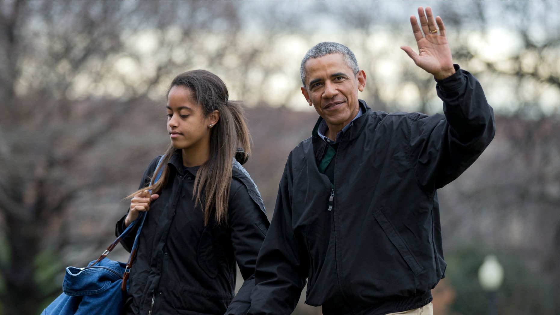 Jan. 4, 2015: President Barack Obama, right, with his daughter Malia Obama, waves as they arrive at the White House in Washington.