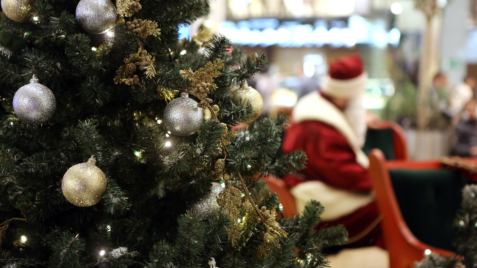 Santa Claus in Shopping Center on defocused lights background