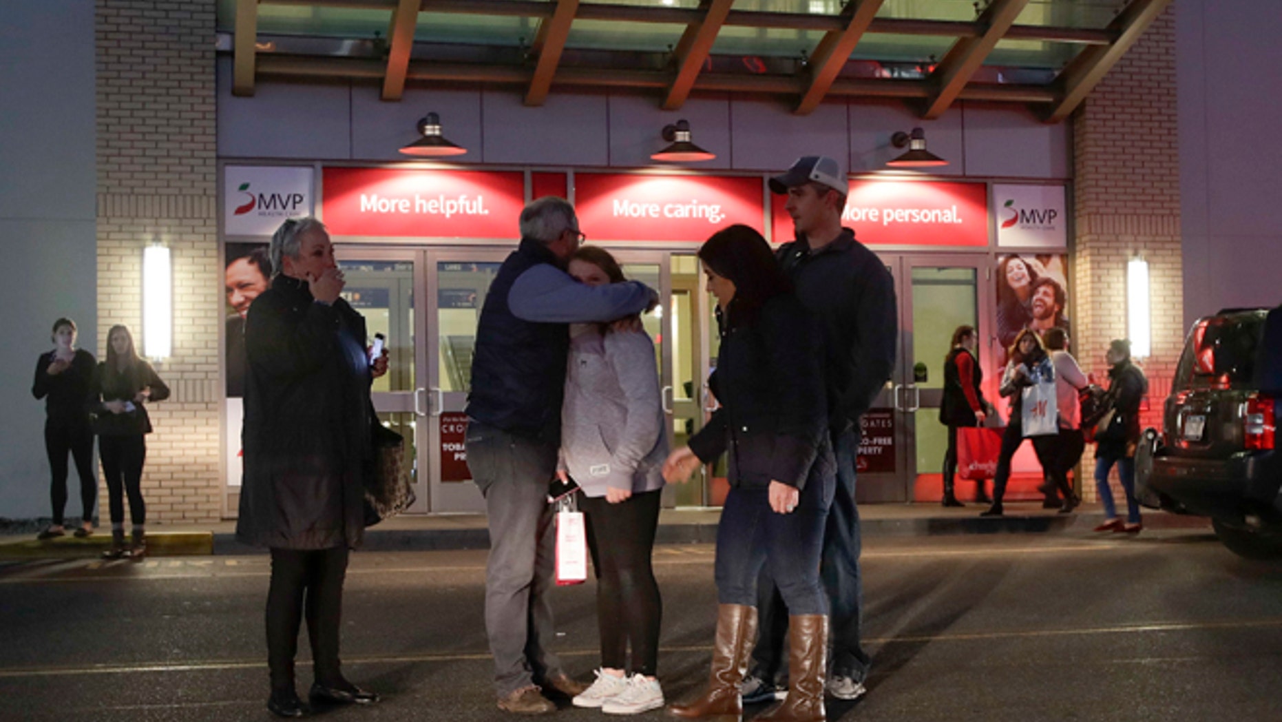 People embrace after leaving Crossgates Mall in Guilderland, N.Y., after reports of gunfire inside, Saturday, Nov. 12, 2016. The Albany Times-Union says hundreds of people were evacuated and the mall was locked down. (AP Photo/Michael Groll)