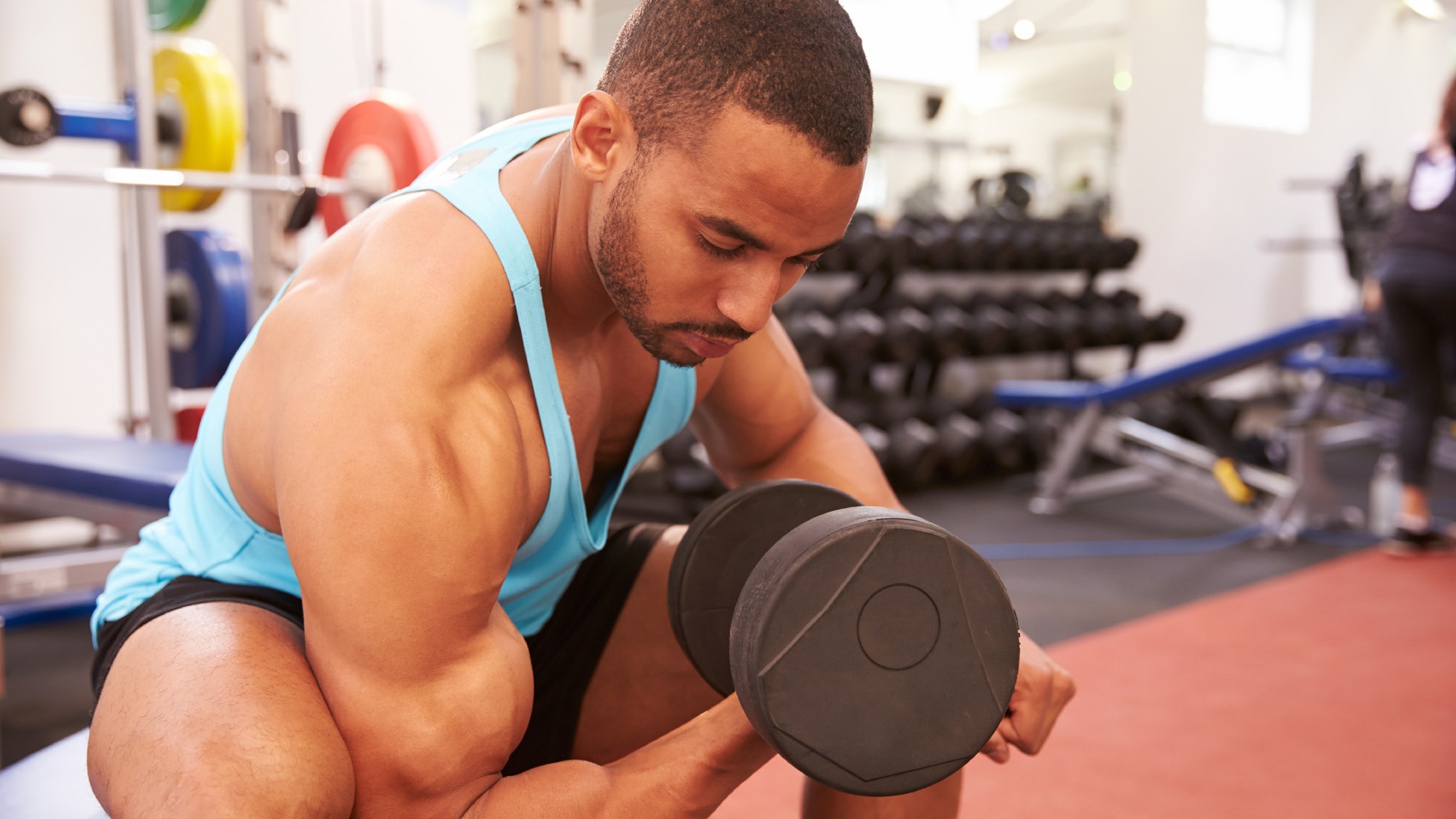 Man exercising with dumbbells at a gym, horizontal shot