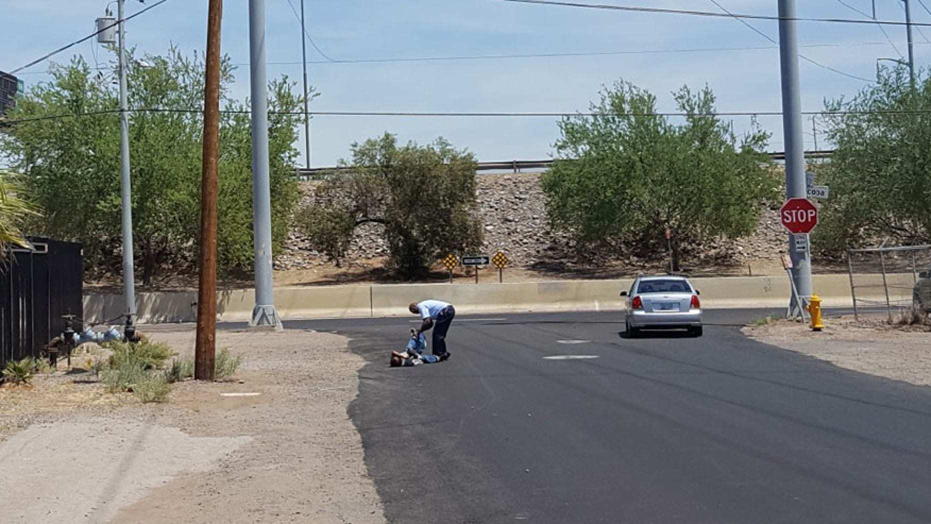 David Lee Witherspoon Jr., bent down to help man put on shoes. Captured by Lee Henry, Kitchen Manager of the St. Vincent de Paul food pantry in Phoenix.