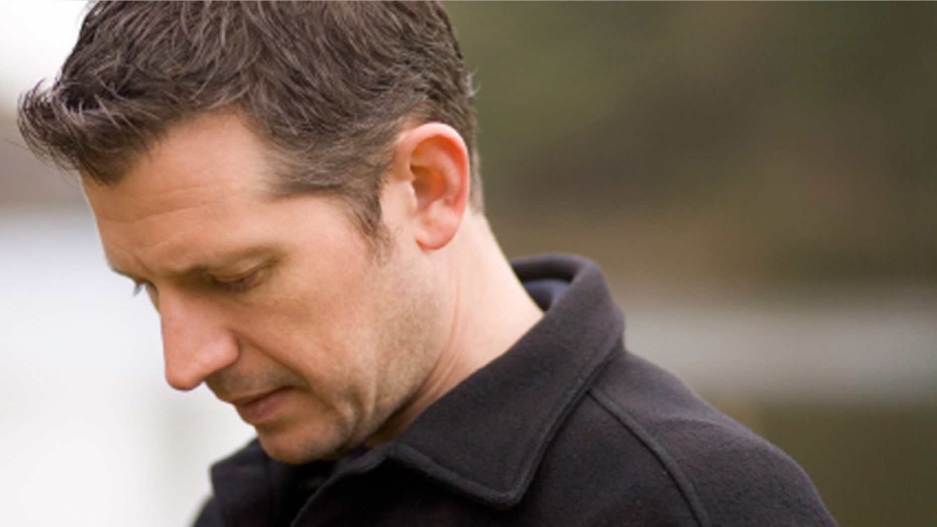 Portrait of adult male, his head down with sadness.