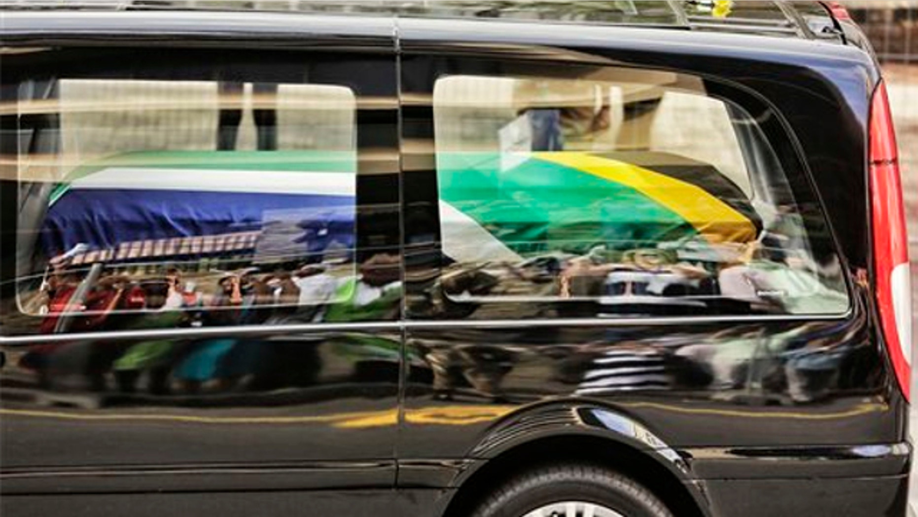 Dec. 11, 2013: People are reflected in the car carrying former South African president Nelson Mandela as it makes its way through the streets of Pretoria, South Africa.