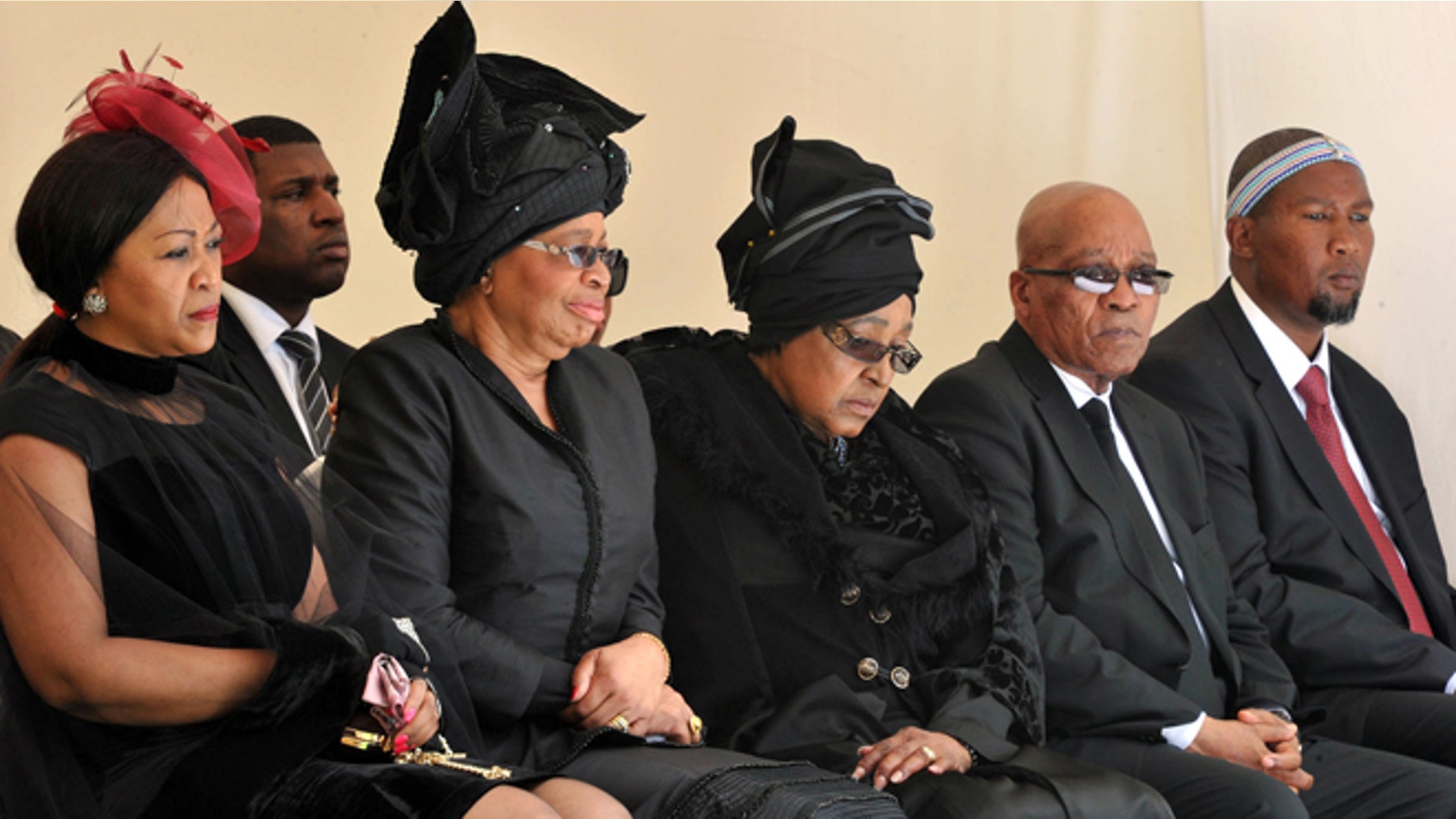 Dec. 15, 2013: From left: Tobeka Zuma, Nelson Mandelas widow Graca Machel, Winnie Madikizela-Mandela, Nelson Mandela's former wife, South African President Jacob Zuma, and Mandela's grandson Mandla Mandela watch as former South African President Nelson Mandela's casket arrives at his burial site following his funeral service in Qunu, South Africa.