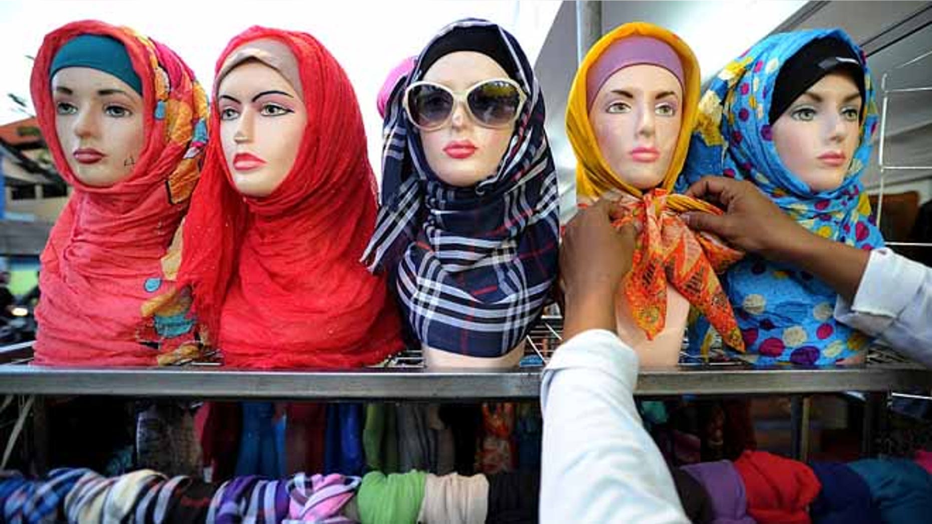 SURABAYA, INDONESIA - JUNE 17: A vendor prepares hijabs for sale during Ramadan on June 17, 2015 in Surabaya, Indonesia. Muslims worldwide observe Ramadan, the ninth month of the Islamic calendar which is marked by a holy month of fasting, prayer, and recitation of the Quran. (Photo by Robertus Pudyanto/Getty Images)