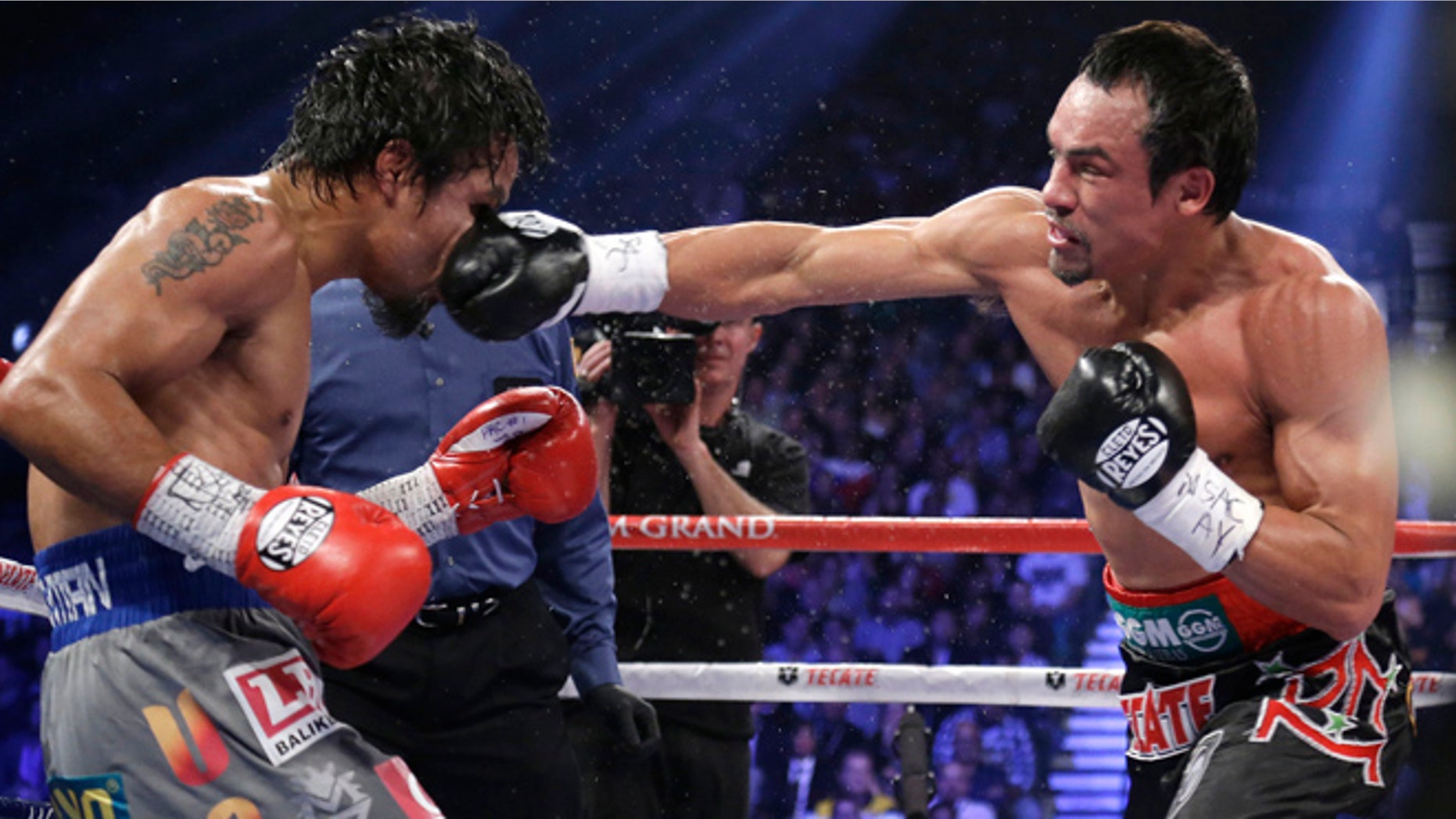 Dec. 8, 2012: Juan Manuel Marquez, right, lands a right to the head of Manny Pacquiao during their WBO world welterweight fight in Las Vegas. Marquez won by a knockout. Pacquiao reportedly wants his next bout -- a fifth fight against Marquez -- to be held far away from Sin City and the United States’ 39.6 federal tax rate. (AP)