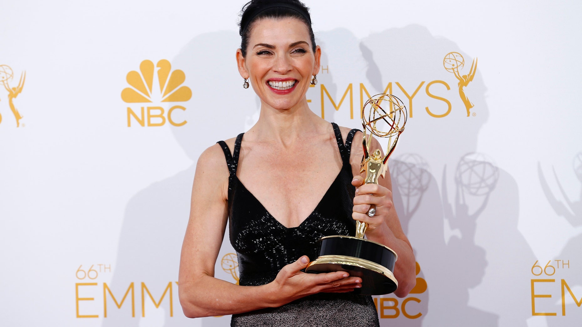 Julianna Margulies poses backstage with her award for Outstanding Lead Actress in a Drama Series for the CBS series "The Good Wife" at the 66th Primetime Emmy Awards in Los Angeles, California August 25, 2014. REUTERS/Mike Blake (UNITED STATES -Tags: ENTERTAINMENT)(EMMYS-BACKSTAGE) - RTR43QQV