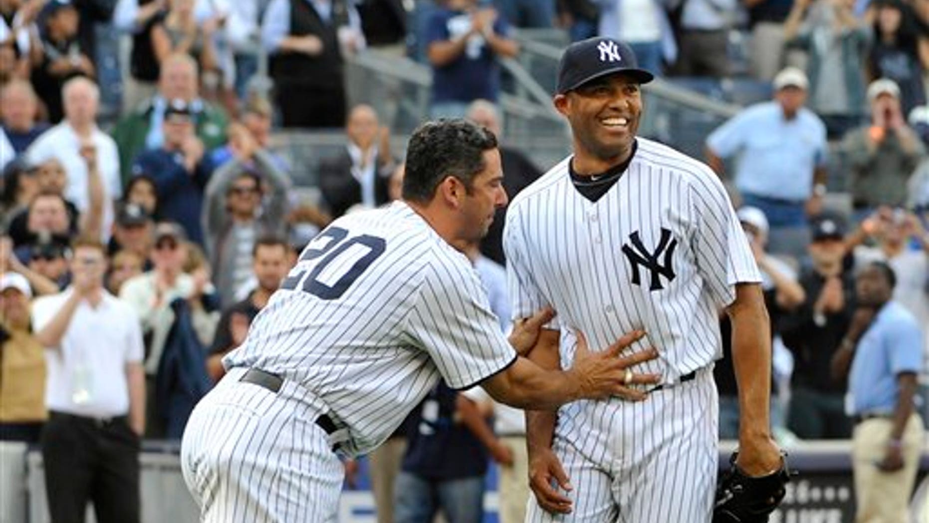 Sept 19: New York Yankees Jorge Posada pushes Mariano Rivera, right, back to the mound to acknowledge the cheers of the crowd after Rivera recorded his 602nd save as the Yankees beat the Minnesota Twins 6-4 on Monday, Sept. 19, 2011, at Yankee Stadium.