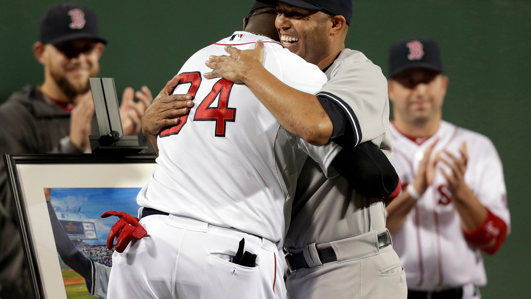 New York Yankees relief pitcher Mariano Rivera, right, hugs Boston Red Sox's David Ortiz during a tribute for Rivera before the start of a baseball game at Fenway Park, in Boston, Sunday, Sept. 15, 2013.