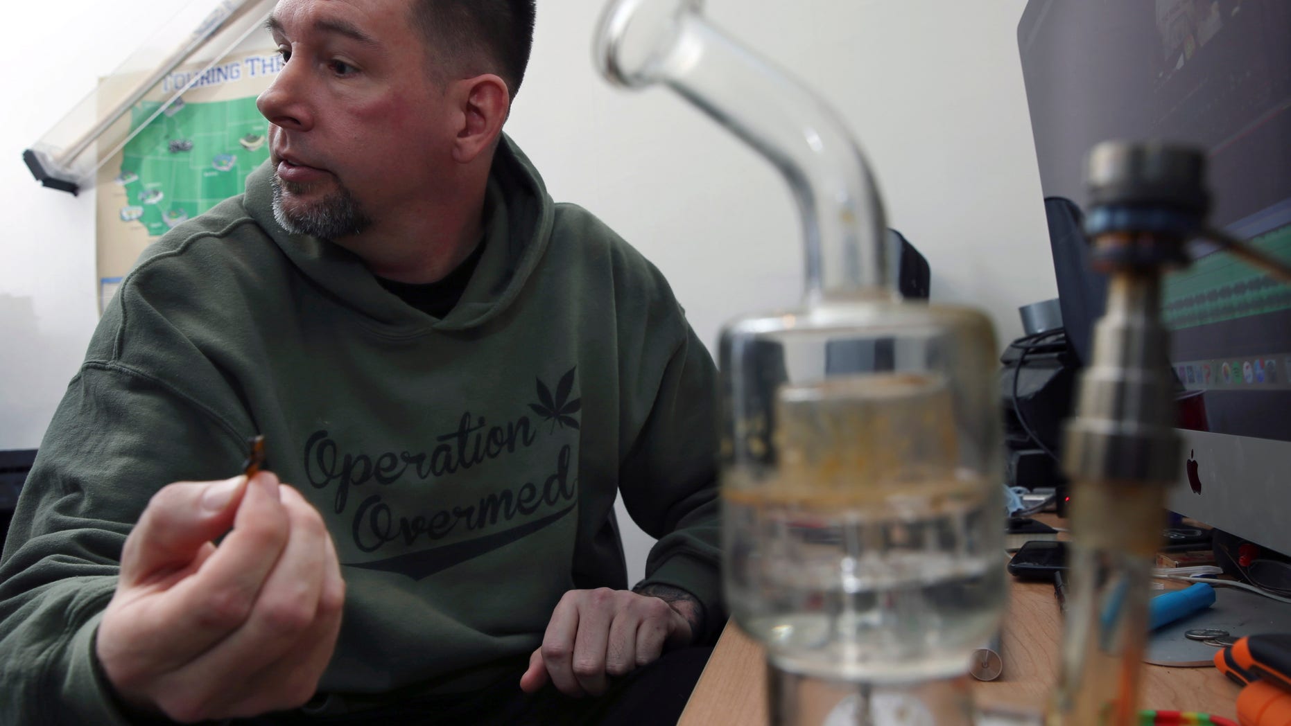 In this Feb. 26, 2016 photograph, a marijuana pipe is nearby, as former U.S. Marine, Mike Whiter answers a question about his marijuana use to treat post-traumatic stress disorder, at his home in Philadelphia. A growing number of states are weighing whether to legalize marijuana to treat PTSD. While the research has been contradictory and limited, some former members of the military say marijuana helps them manage their anxiety, insomnia and nightmares. (AP Photo/Mel Evans)