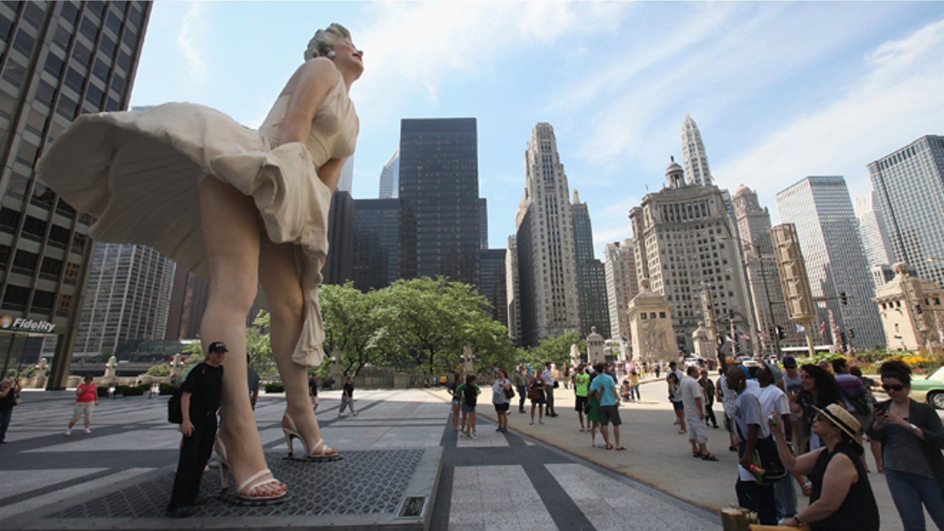 CHICAGO, IL - JULY 15: Spectators look at 'Forever Marilyn,' a sculpture by Seward Johnson, on July 15, 2011 in Chicago, Illinois. The stainless steel and aluminum sculpture which stands 26 feet tall and weighs 34,000 pounds will be on display in Chicago through the spring of 2012. The sculpture was inspired by Marilyn Monroe?s iconic scene in the 1955 movie Seven Year Itch. (Photo by Scott Olson/Getty Images)