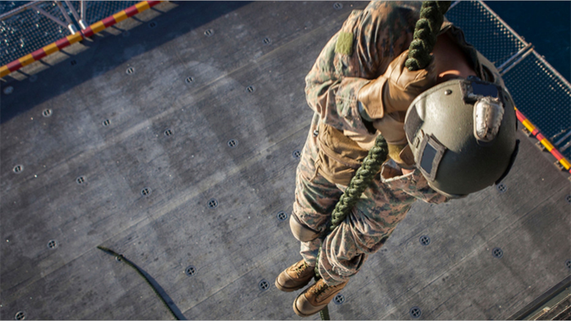 A Marine with the Force Reconnaissance Platoon, Maritime Raid Force, 31st Marine Expeditionary Unit, fast ropes out of a MV-22 Osprey aircraft on to the elevator below the flight deck August 10.
