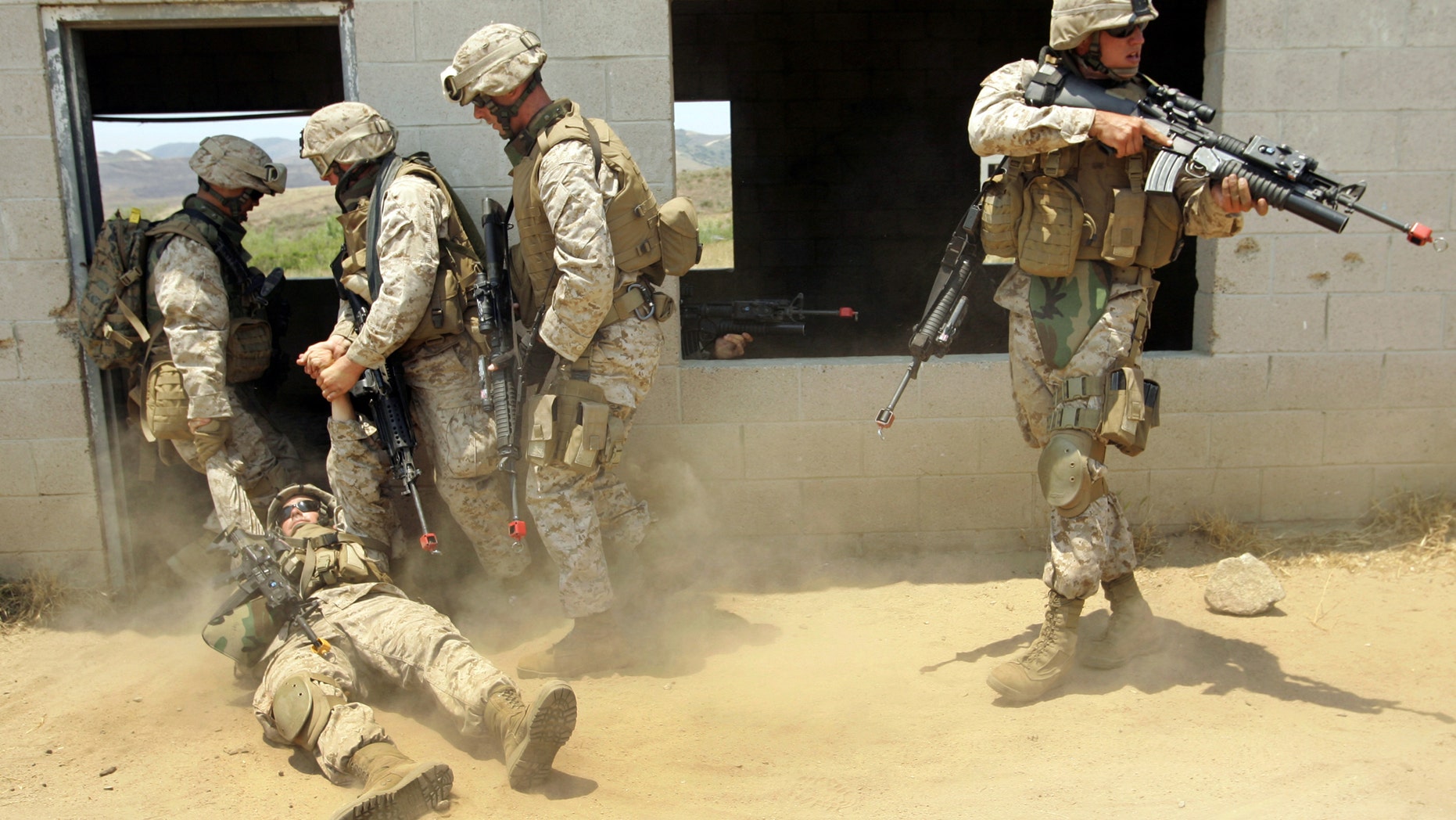 File photo - U.S. Marines carry a "wounded" soldier, injured by a simulated improvised explosion, during a simulated training of a search through an Iraqi city built at the U.S. Marine Base in Camp Pendleton, California, June 29, 2006. (REUTERS/Mike Blake)