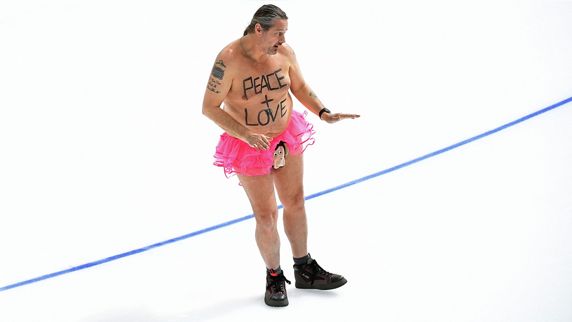 A shirtless man clad in a tutu dances on the rink following the men's 1,000m speed skating event medal ceremony during the Pyeongchang 2018 Winter Olympic Games at the Gangneung Oval in Gangneung on February 23, 2018.