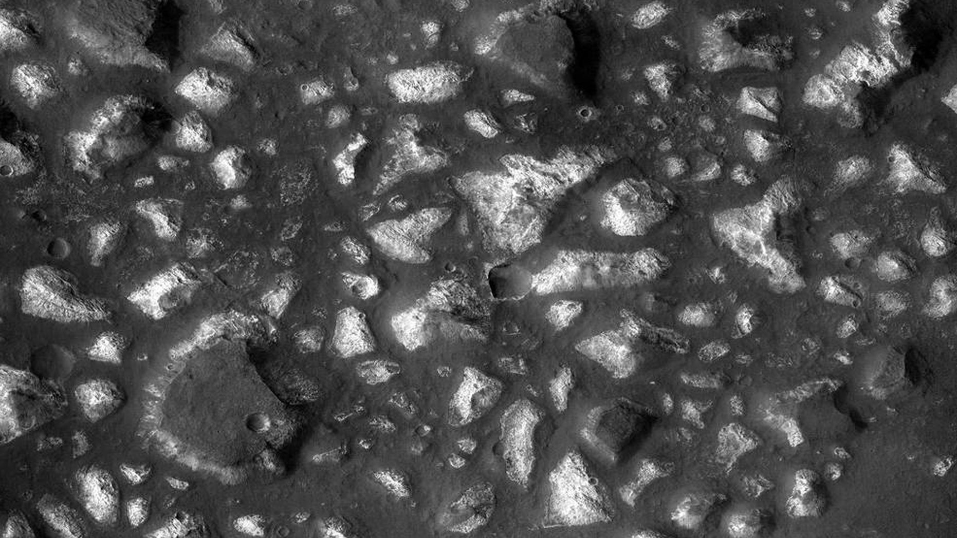 This view of a portion of the Eridania region of Mars shows blocks of deep-basin deposits that have been surrounded and partially buried by younger volcanic deposits. The image was taken by the Context Camera on NASA's Mars Reconnaissance Orbiter and covers an area about 12 miles wide. (Credits: NASA/JPL-Caltech/MSSS)