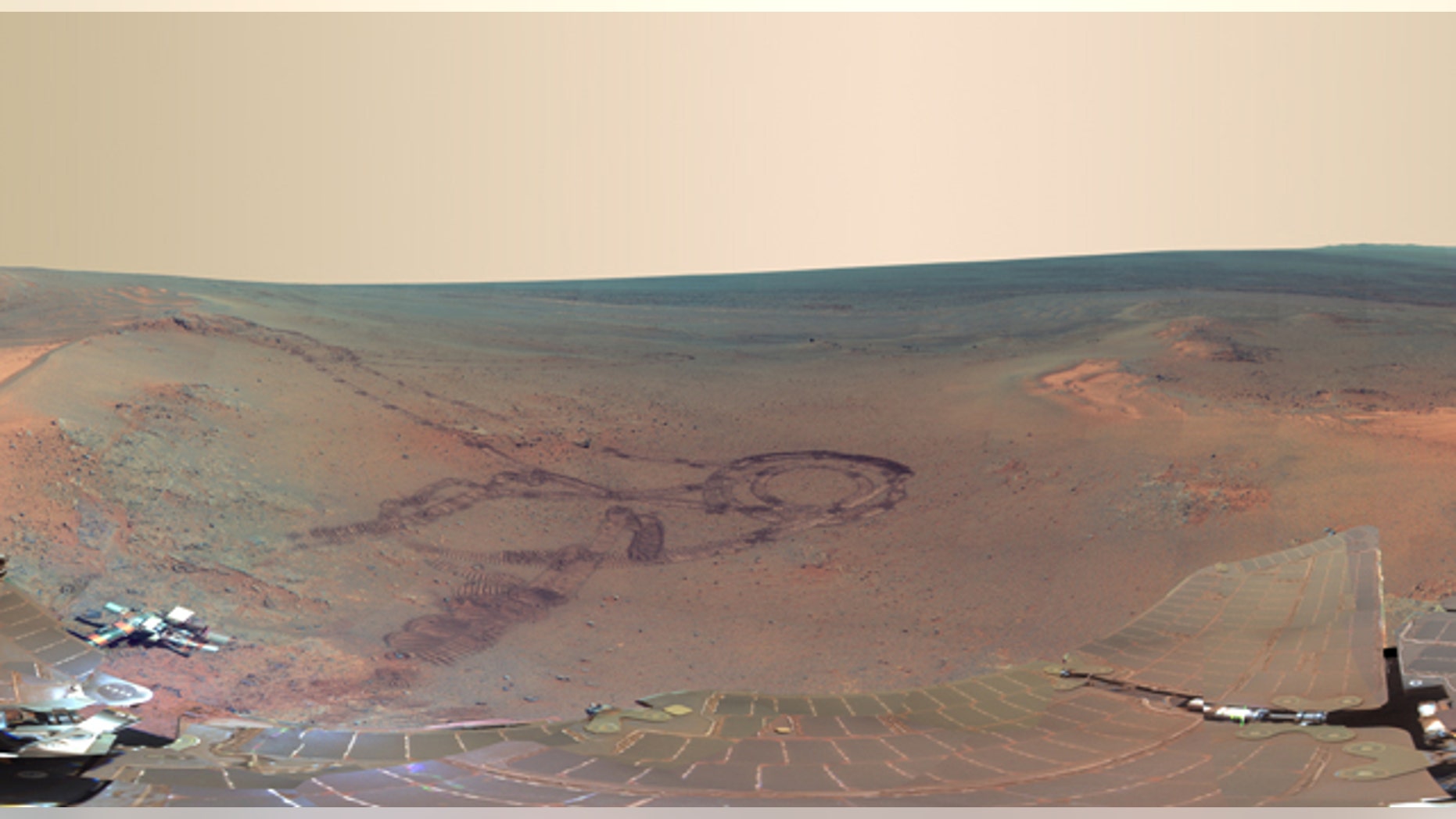July 5, 2012: From fresh rover tracks to an impact crater blasted billions of years ago, a newly completed view from the panoramic camera (Pancam) on NASA's Mars Exploration Rover Opportunity shows the ruddy terrain around the outcrop where the long-lived explorer spent its most recent Martian winter.