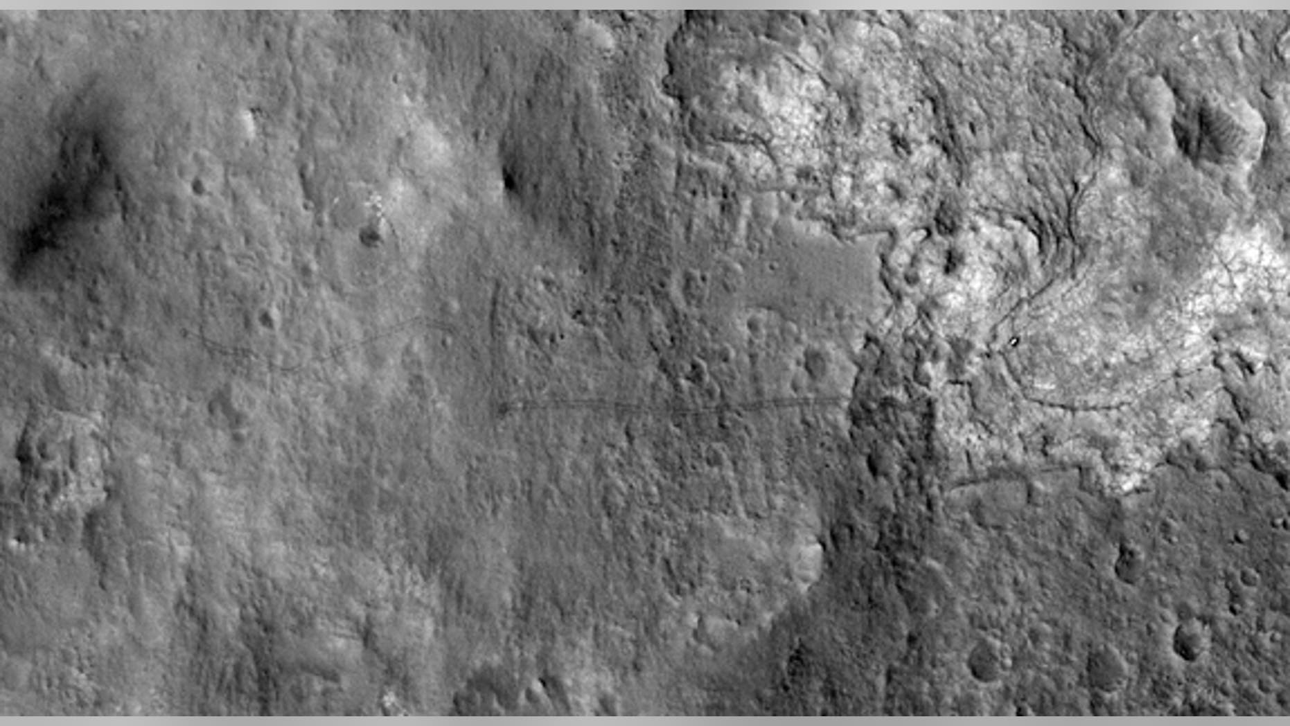 Jan. 2, 2013: The Curiosity rover's tracks are seen on the Red Planet: Curiosity's landing site is the dark smudge at left; the rover is visible as a bright speck amid the light-colored terrain toward the right.