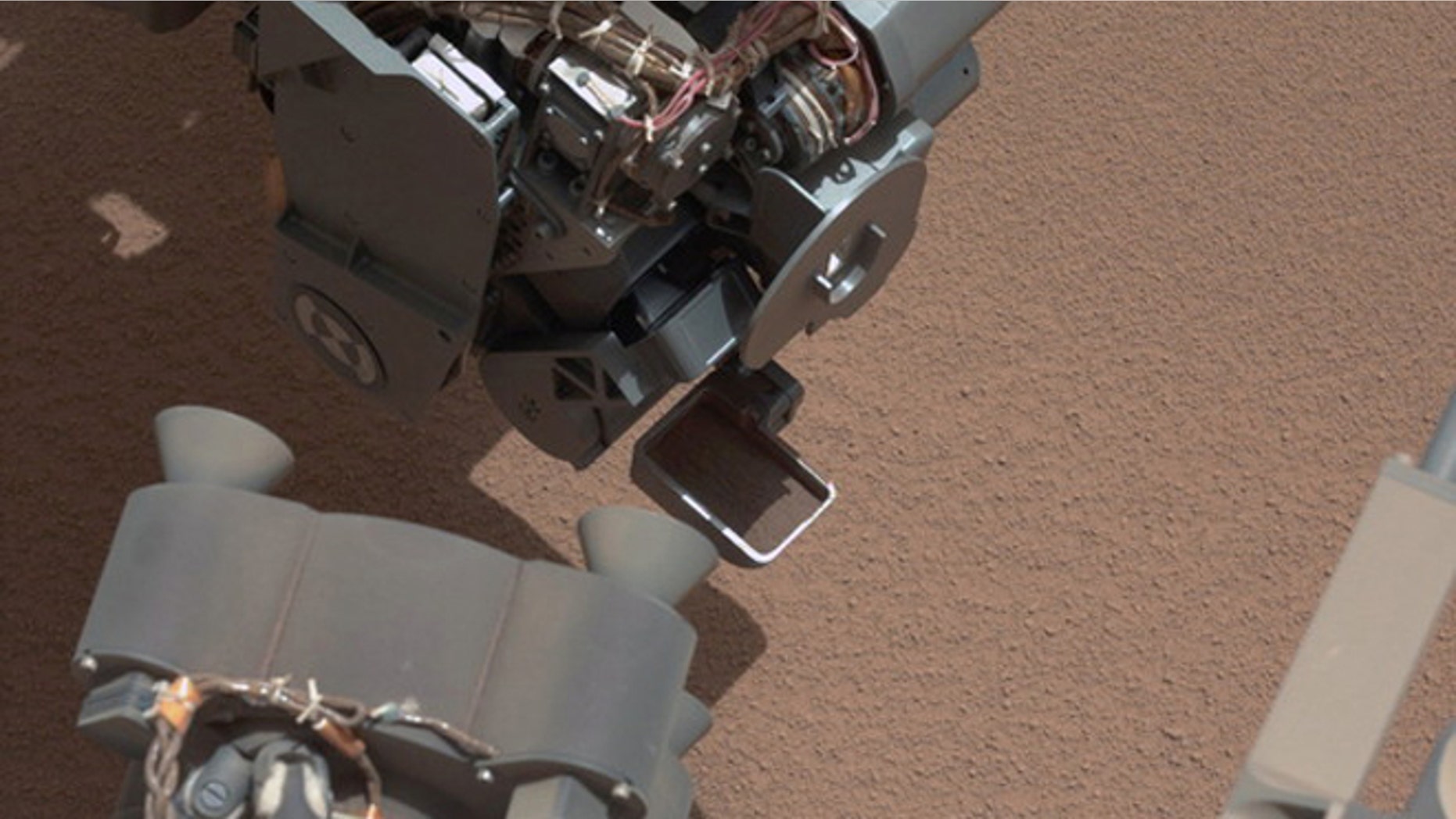 his image from the right Mast Camera (Mastcam) of NASA's Mars rover Curiosity shows a scoop full of sand and dust lifted by the rover's first use of the scoop on its robotic arm. In the foreground, near the bottom of the image, a bright object
