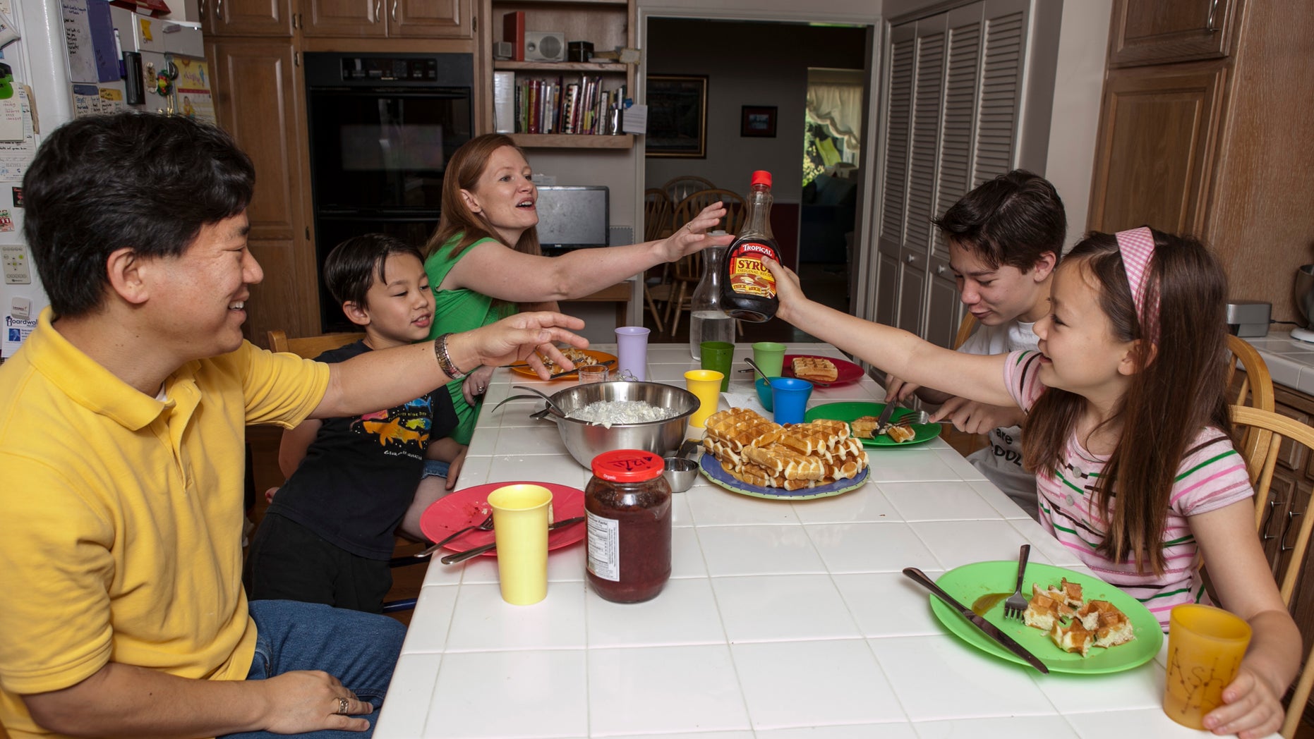 In this photo taken Tuesday, Aug. 14, 2012, David Oh, a flight director of NASA's latest Mars mission, far left and his family have breakfast at 3 pm at their home in La Canada Flintridge, Calif. The Oh family has been living on Mars time and following an odd schedule ever since the NASA rover Curiosity landed in an ancient Martian crater on Aug. 5. Siting from left: David, Devyn, his wife Bryn, Braden, and Ashlyn. (AP Photo/Damian Dovarganes)