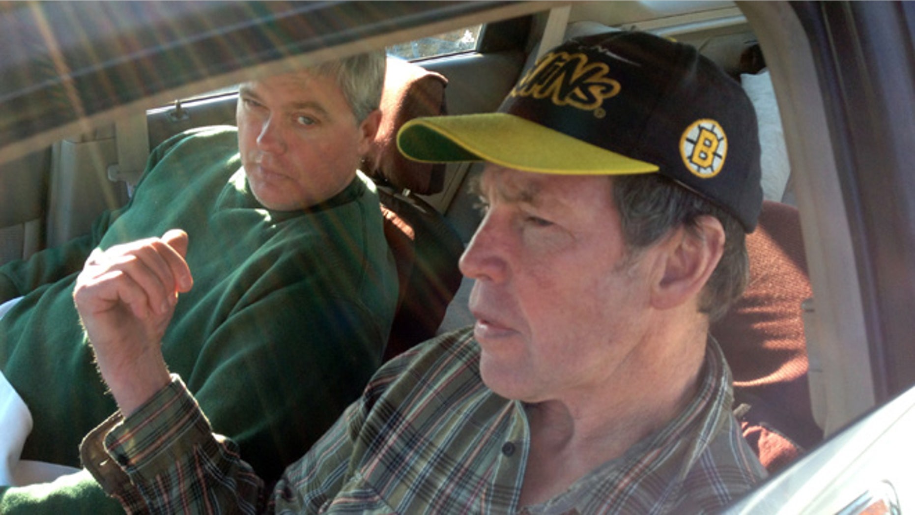 In this photo made Saturday, Oct. 19, 2013, Fred Schaeffer, left, of Raymond, N.H. and George Reynolds, right, of Derry, N.H. sit in a car after being rescued in waters off of Salem, Mass. The two New Hampshire men whose boat capsized off the Massachusetts coast prayed and sang gospel songs as they survived a 15-hour ordeal that ended with them being rescued by a passing fishing boat. The men spent Friday night sitting on a plank over two hulls of a 25-foot trimaran as waves crashed over them through the night.