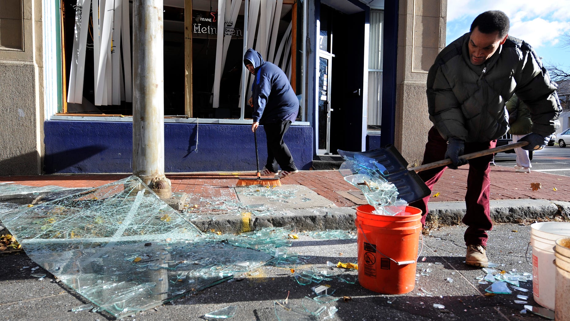 Nov. 24, 2012: Robert Spano, left, and Alan Hugley clean up broken glass, outside of Punta cana Restaurant & Bar, a few blocks from the site of a Friday-evening gas explosion that leveled a strip club in Springfield, Mass.