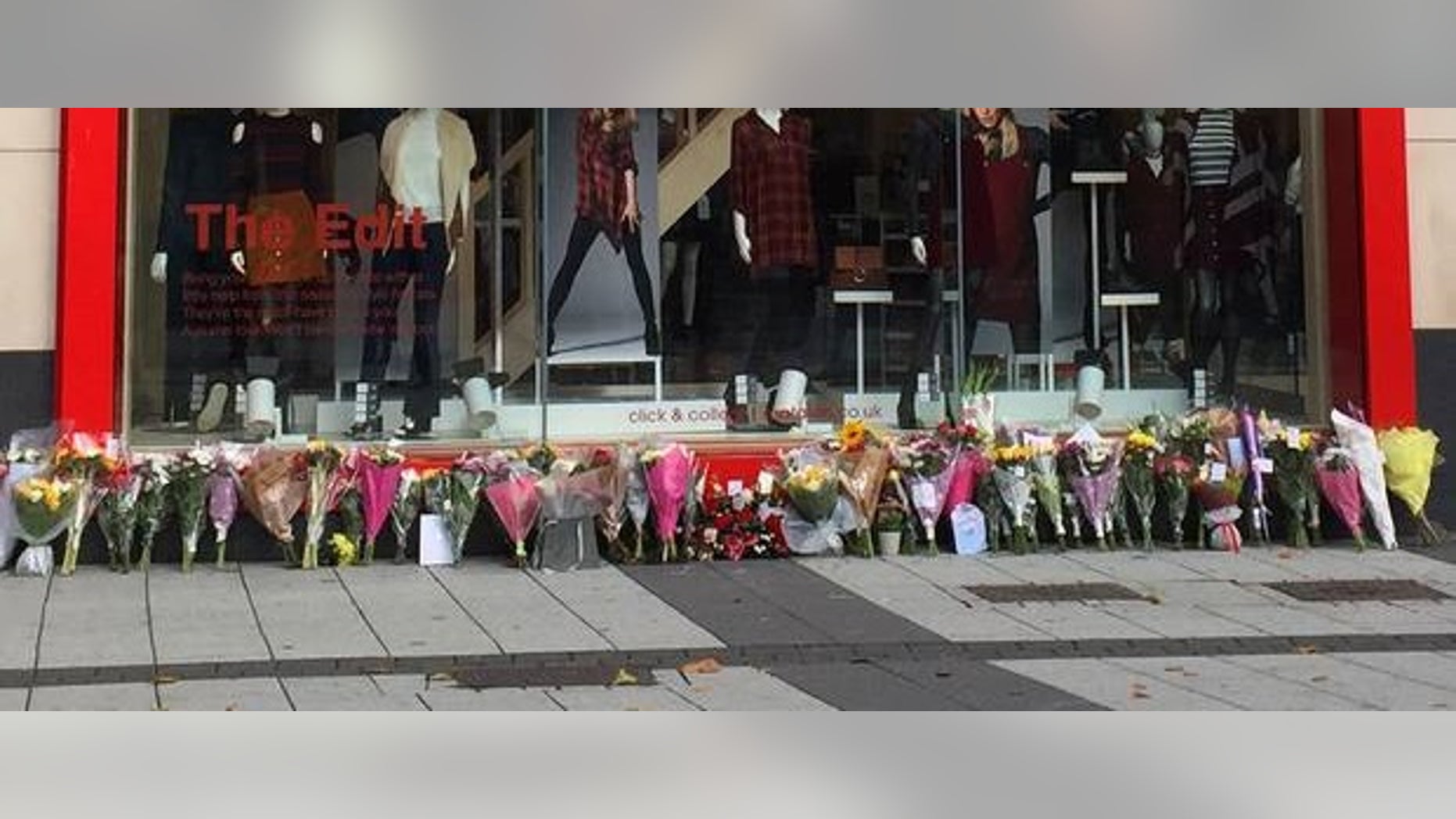 Flowers left outside the store where the couple worked, after the murders last September.