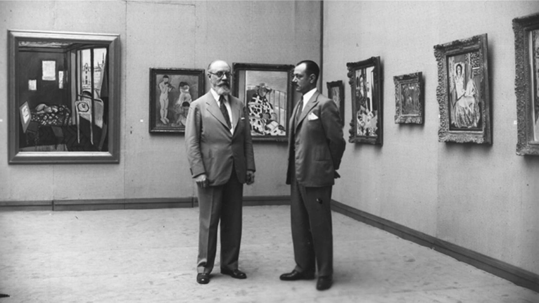 1931: The French painter Henri Matisse (1869 - 1954) (left) at an exhibition of his work at the Galerie Georges Petit, Paris. The exhibition was organised by the collector Etienne Bignou (right). (Photo by Hulton Archive/Getty Images)