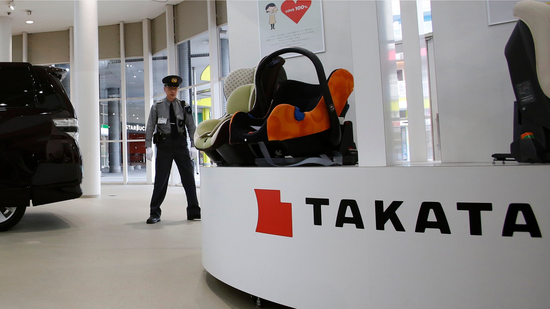 Nov. 6, 2014: A security guard stands by child seats, manufactured and displayed by Takata Corp. at an automaker's showroom in Tokyo.