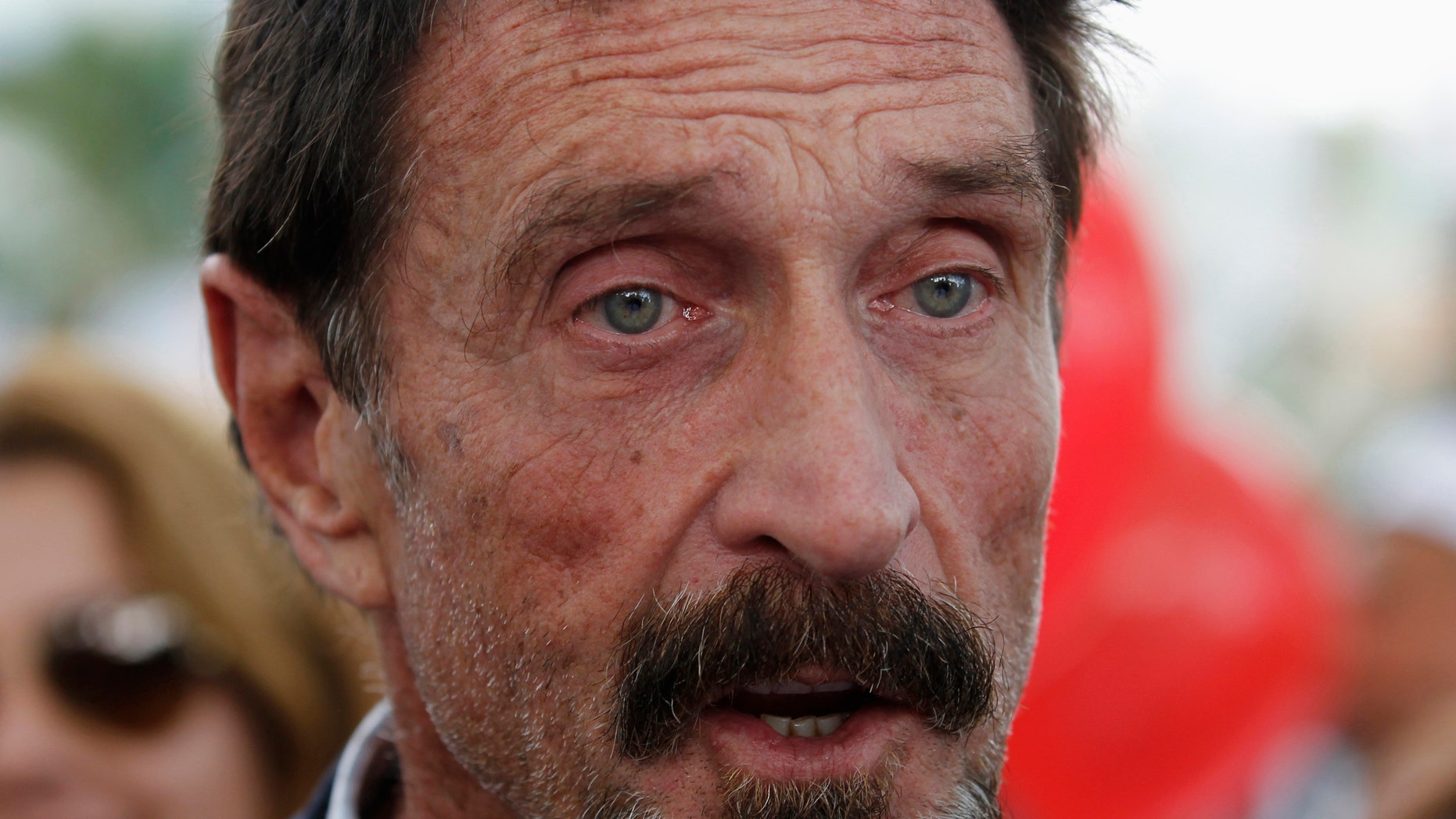 File photo. Computer software pioneer John McAfee speaks with reporters outside his hotel in Miami Beach, Florida December 13, 2012.