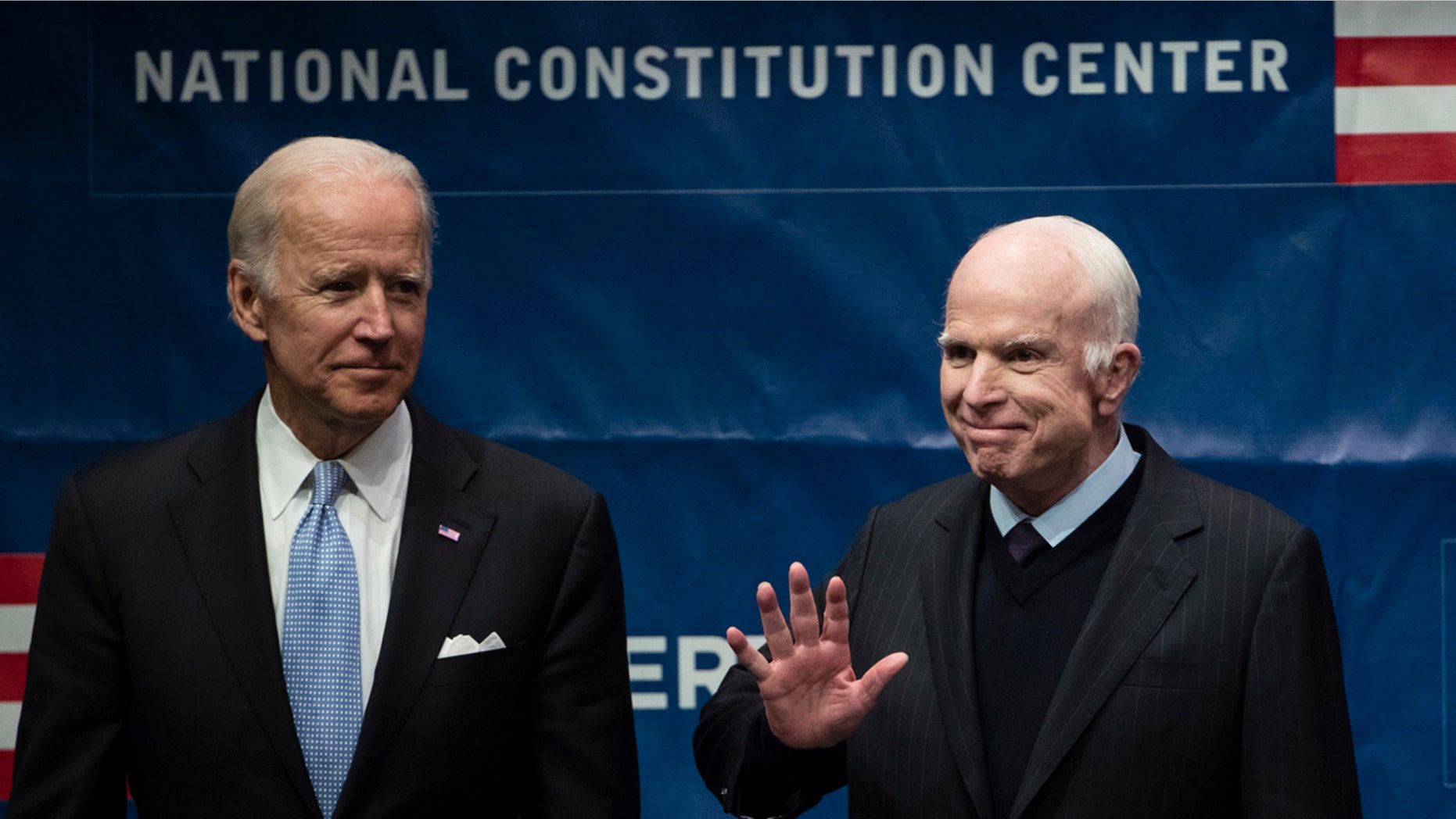 Sen. John McCain, R-Ariz., right, accompanied by Chair of the National Constitution Center's Board of Trustees, former Vice President Joe Biden, waves as he takes the stage before receiving the Liberty Medal in Philadelphia, Monday, Oct. 16, 2017.