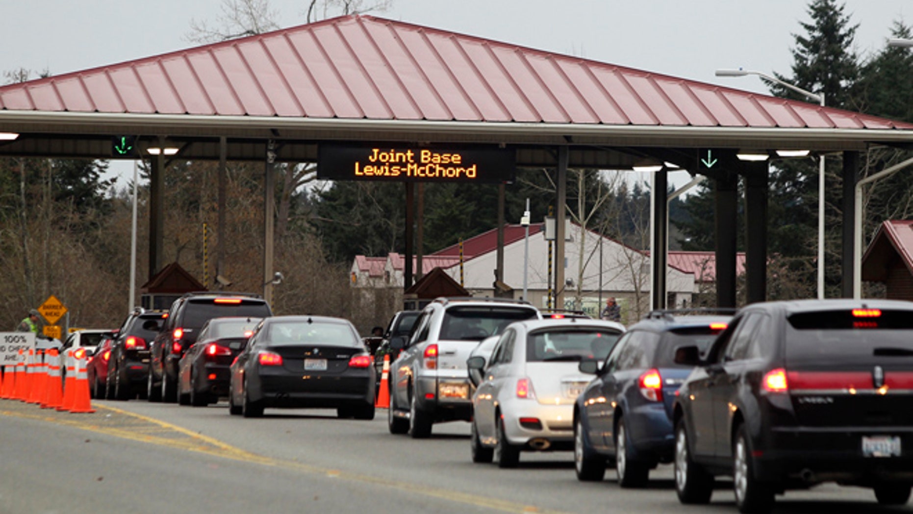 FILE: Commuters drive through the security checkpoint at the Madigan Army Hospital gate of Joint Base Lewis McChord (JBLM.)