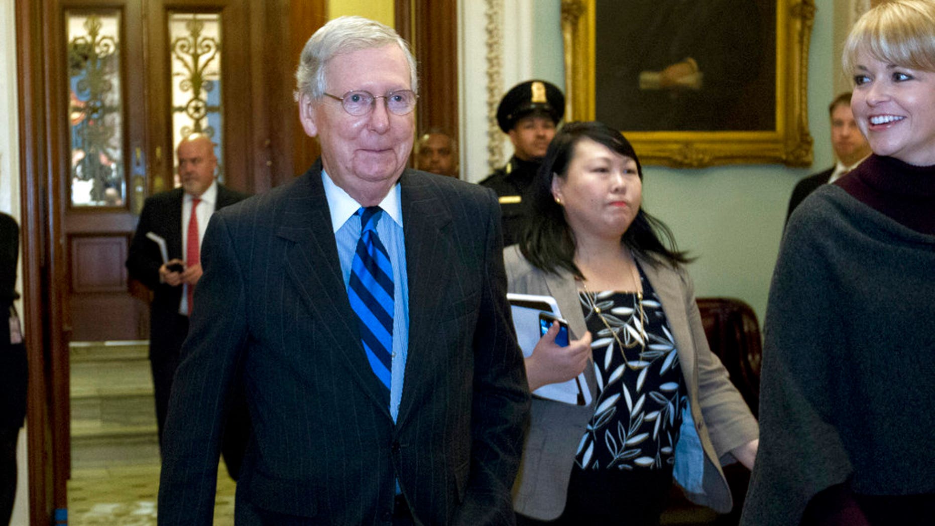 Senate Majority Leader Mitch McConnell, R-Ky., answers to reporters as he walks to his office after speaking on the Senate floor at Capitol, Sunday, Jan. 21, 2018, in Washington. (AP Photo/Jose Luis Magana)