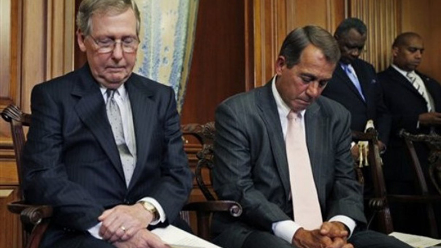 FILE: Senate Minority Leader Mitch McConnell, R-Ky., and House Republican Leader John Boehner, R-Ohio, bow their heads in prayer as they participate in a ceremony on June 16 to unveil plaques recognizing the contributions of enslaved African Americans in the construction of the United States Capitol.